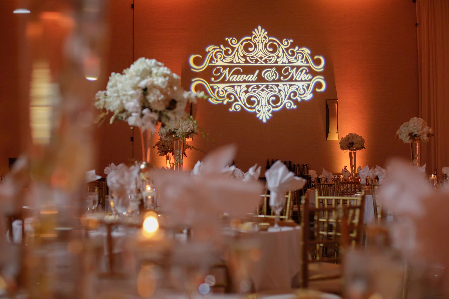 Elegant wedding reception decor with ornate signage and ambient lighting.
