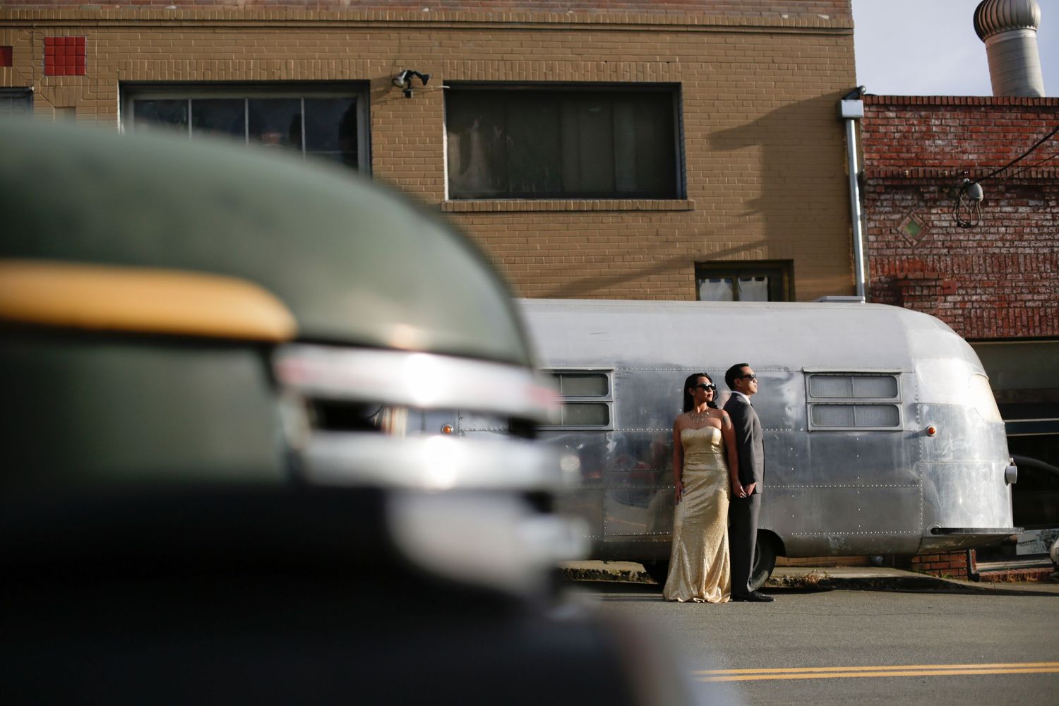 A vintage Airstream trailer serves as backdrop for a formal photo shoot.