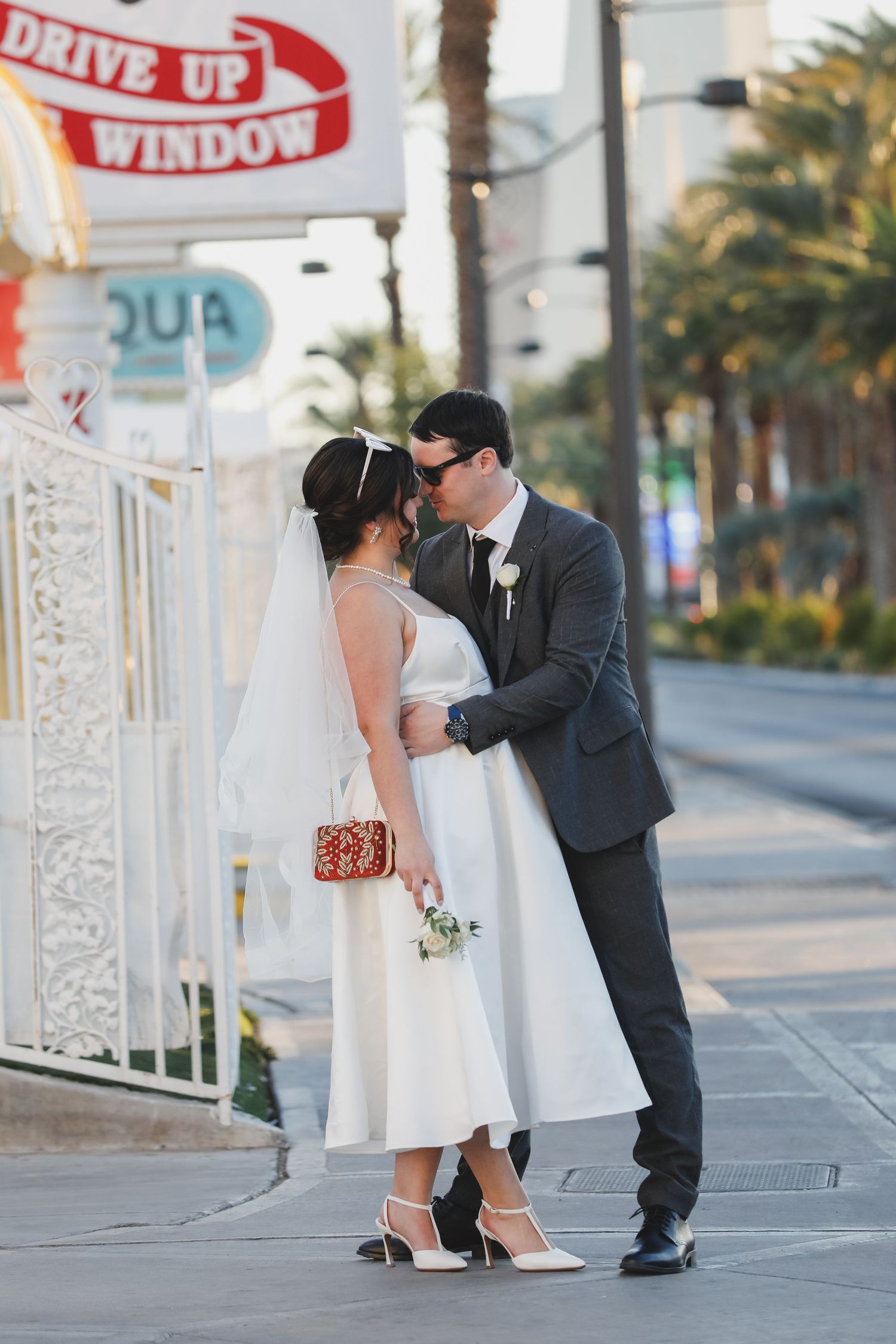 Well-dressed couple share a romantic kiss at sunset outside a vintage style restaurant.