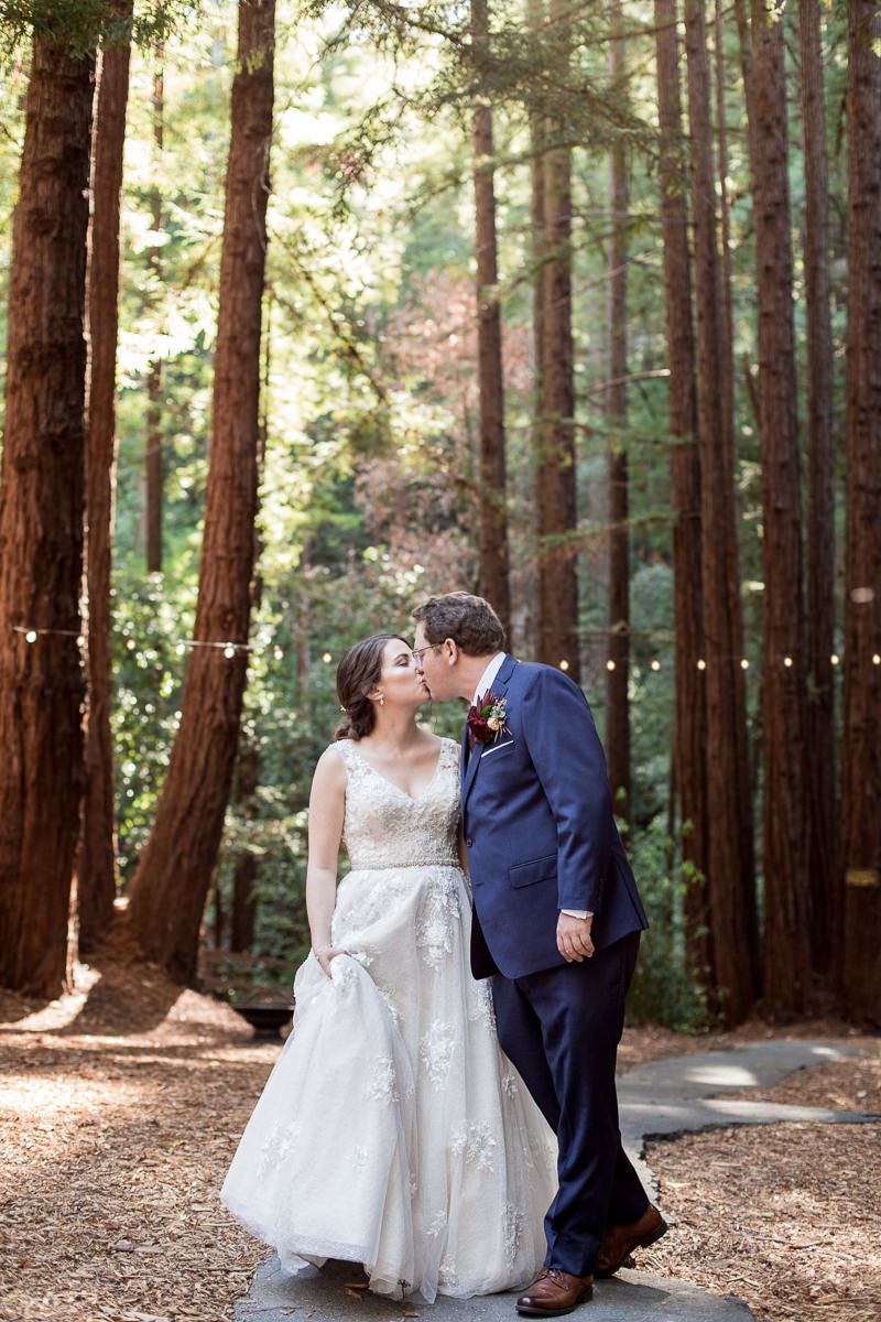Wedding photo of couple sharing intimate moment in majestic redwood forest.