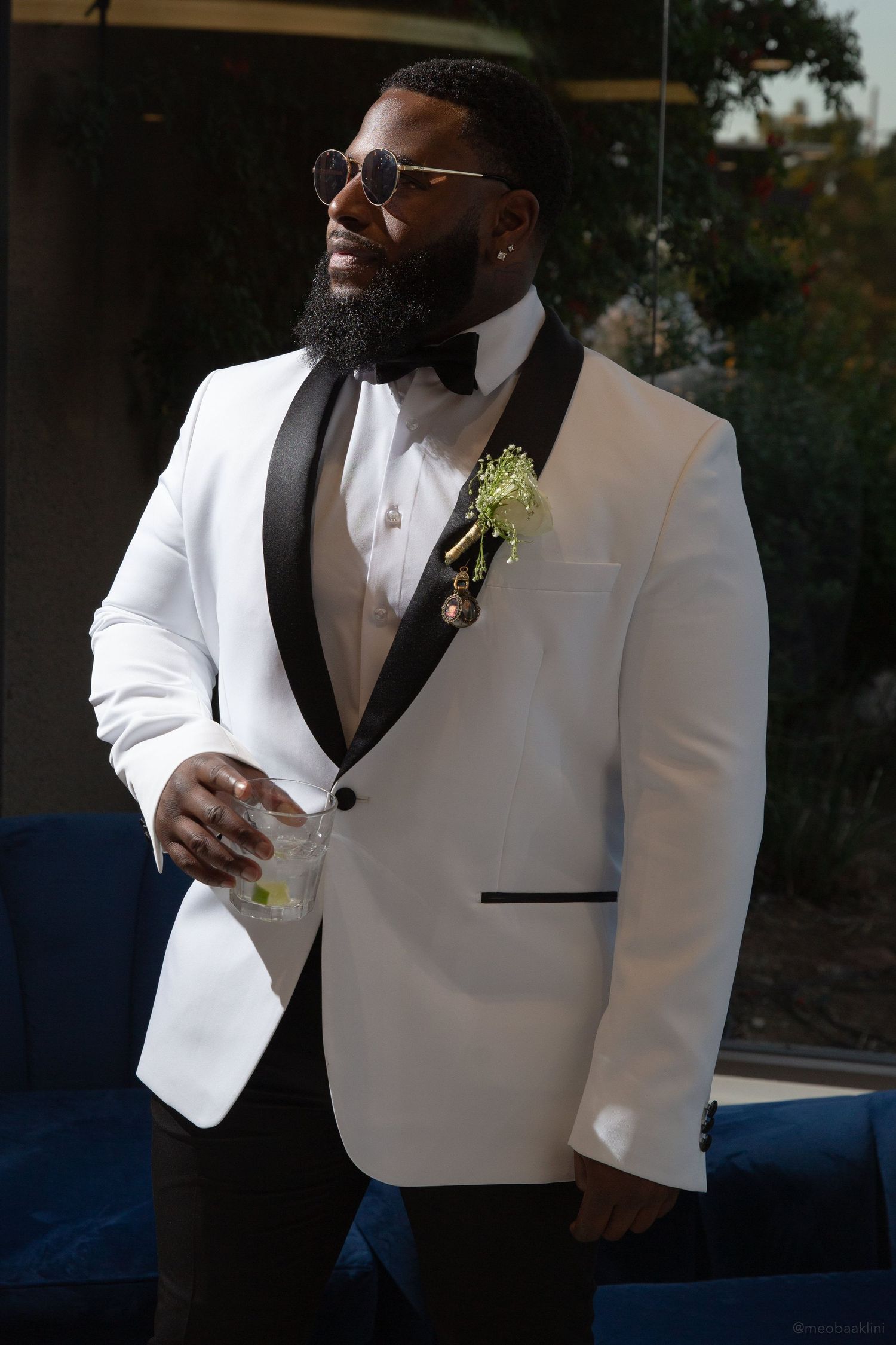 Groom wearing a stylish white tuxedo jacket with black lapels and boutonniere.