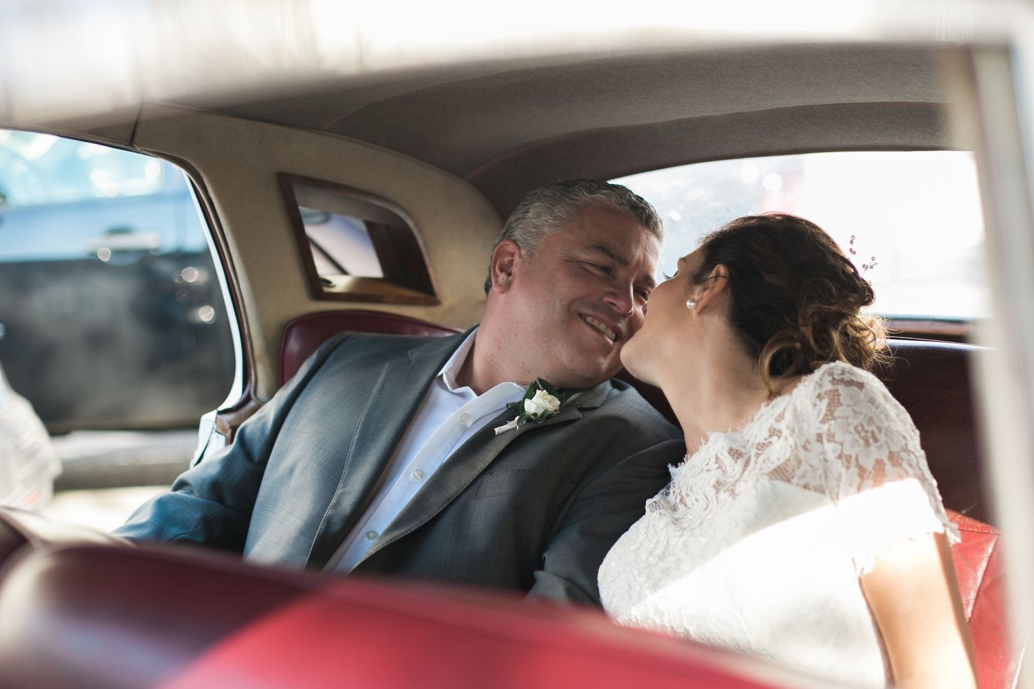 An intimate moment shared in the backseat of a classic car.