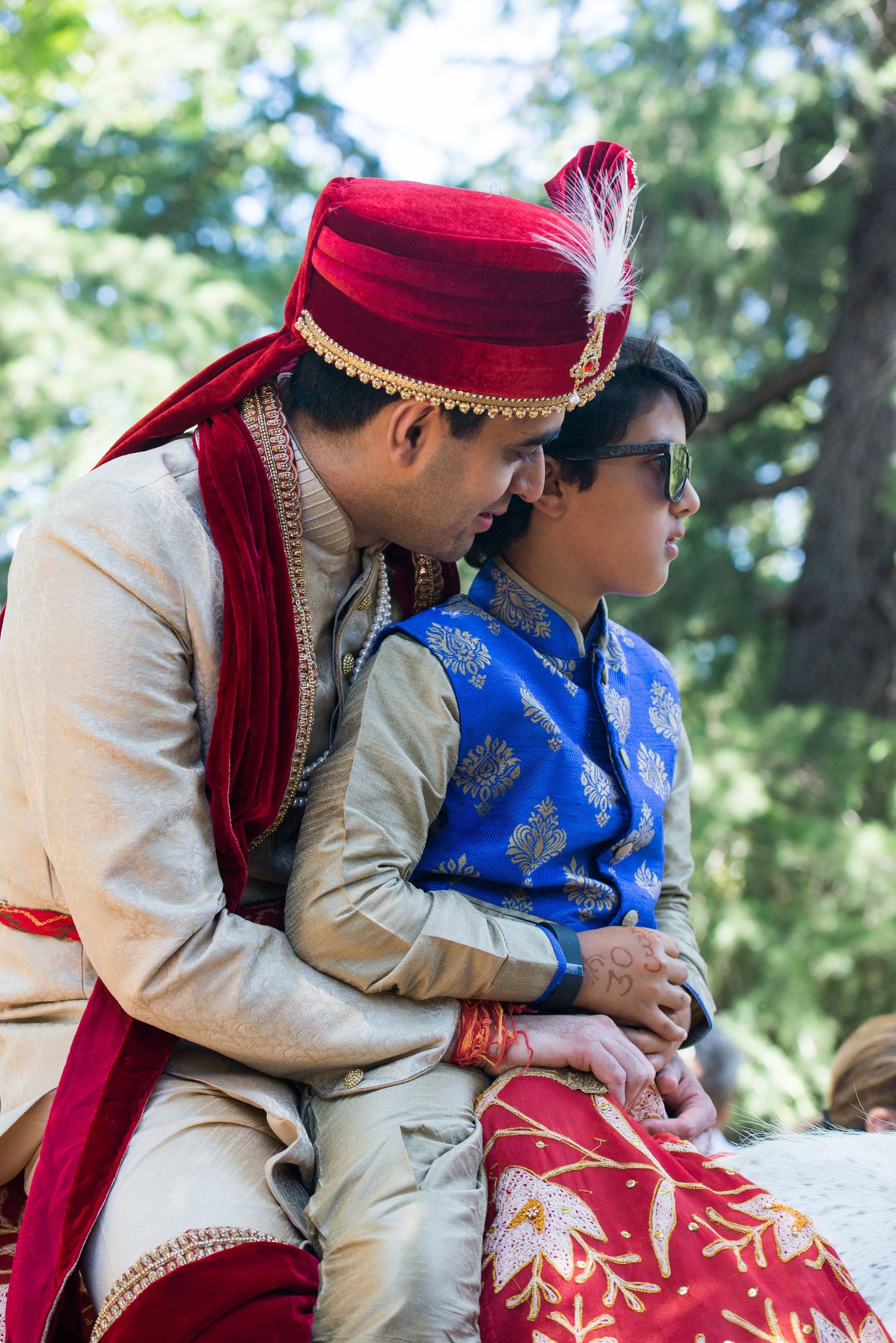 Intimate moment captured outdoors with traditional Indian wedding attire.