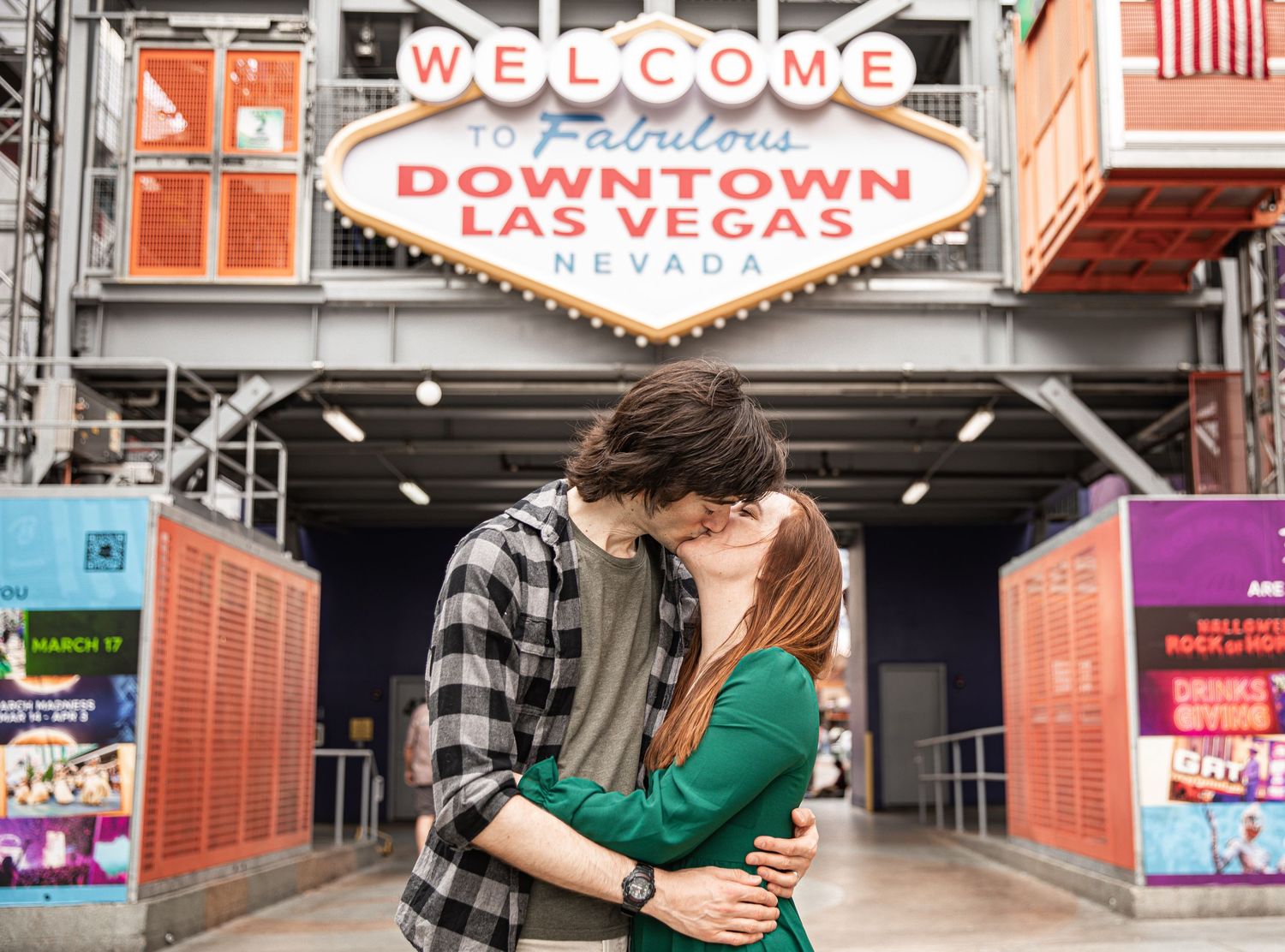 Couple shares romantic moment under Downtown Las Vegas welcome sign.