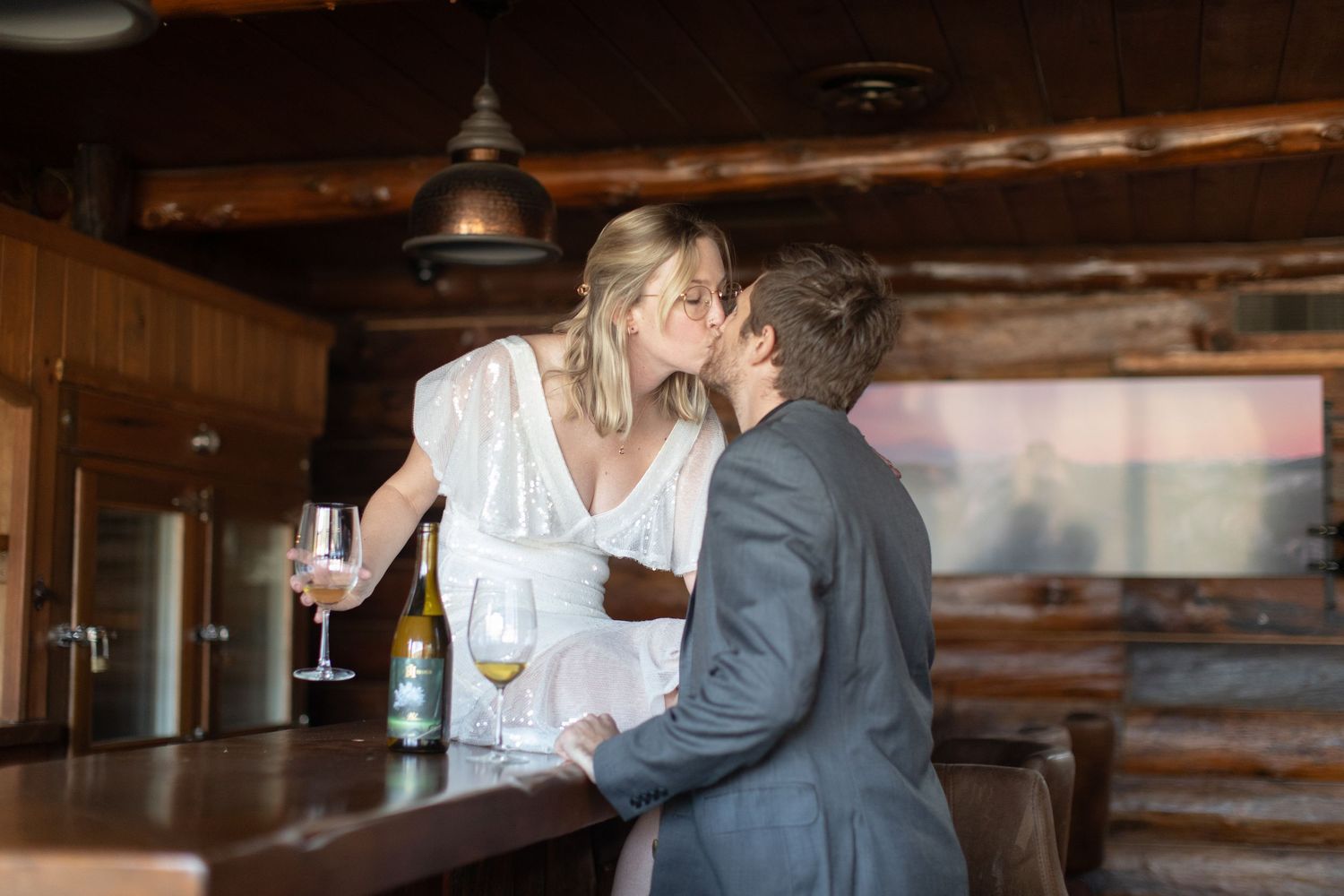 A couple sharing a romantic moment at a rustic bar with cocktails.