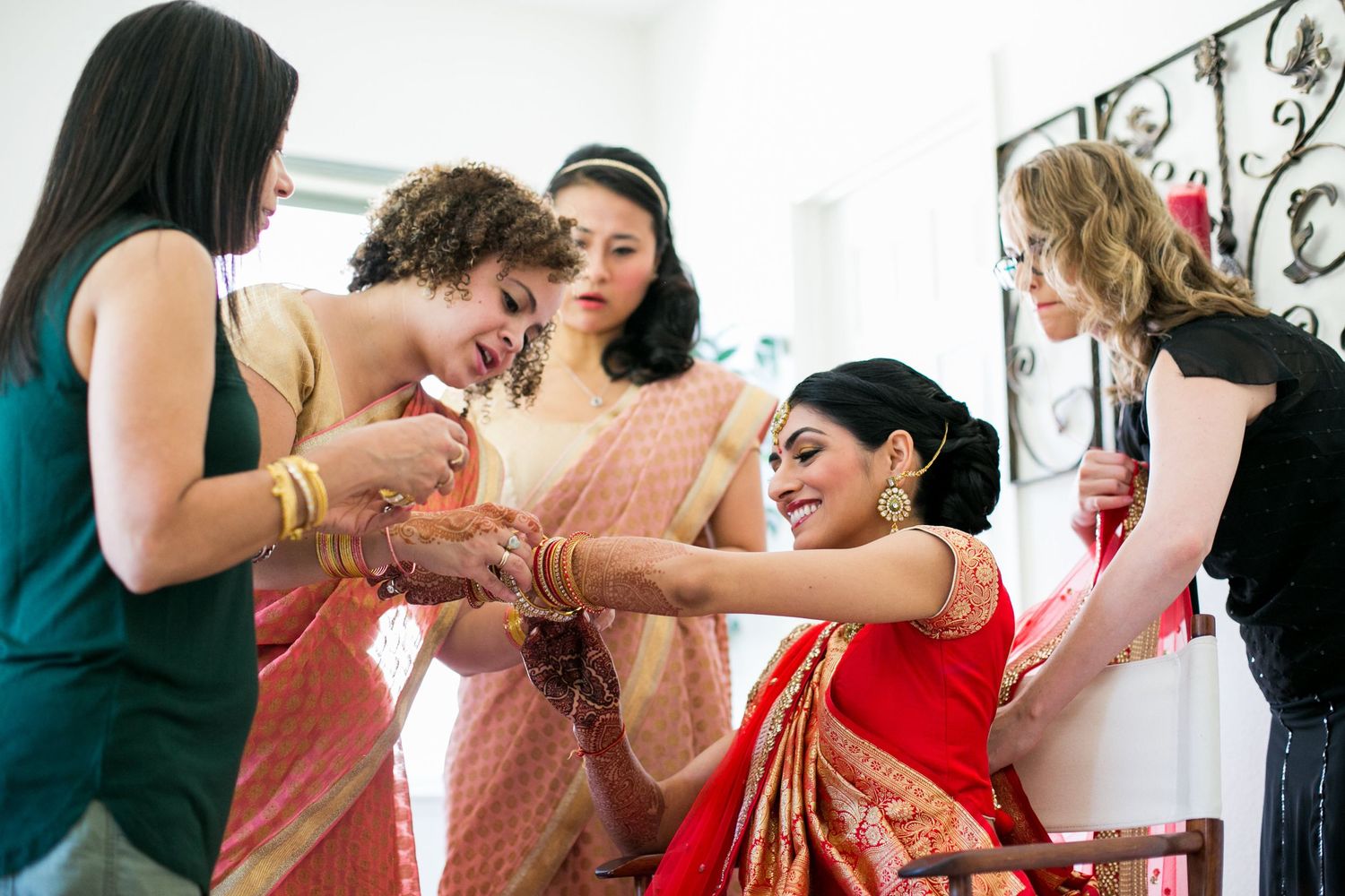 Group helping with traditional Indian bridal preparation and dressing.