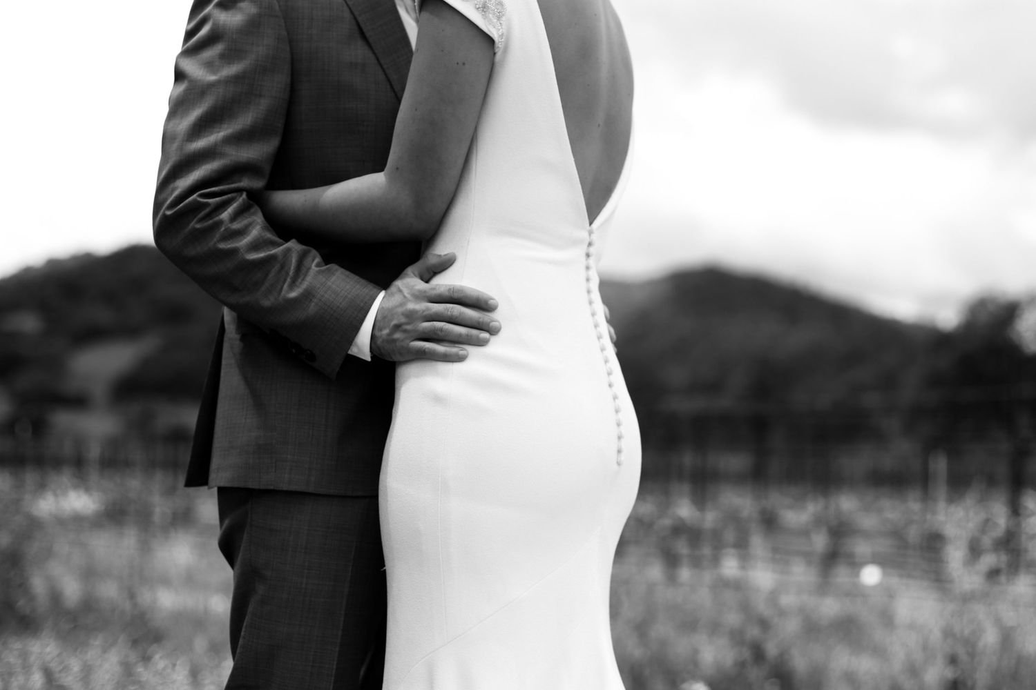 A romantic black and white moment captured between two people in formal attire.