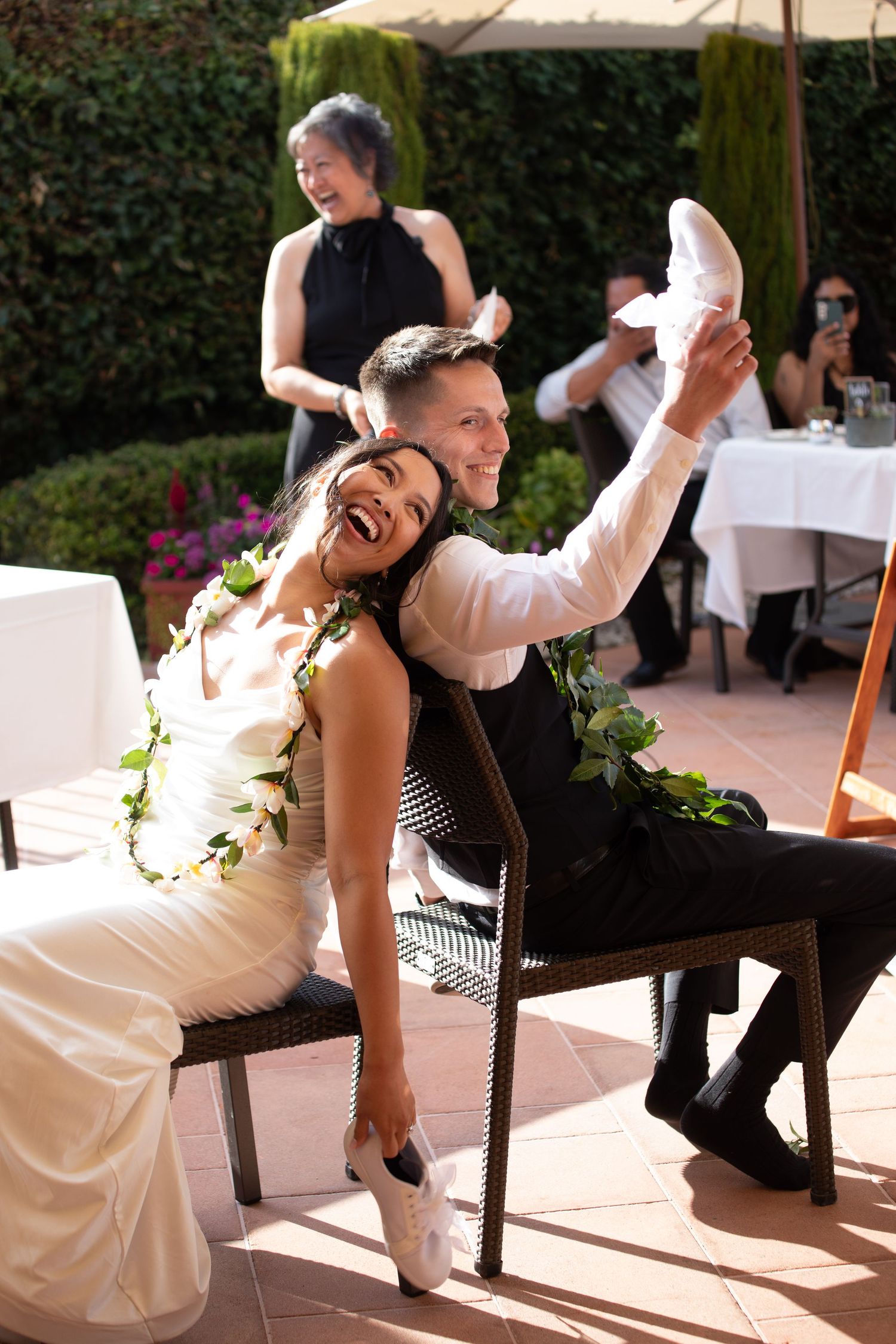 A joyful celebration moment at a wedding reception on an outdoor patio.