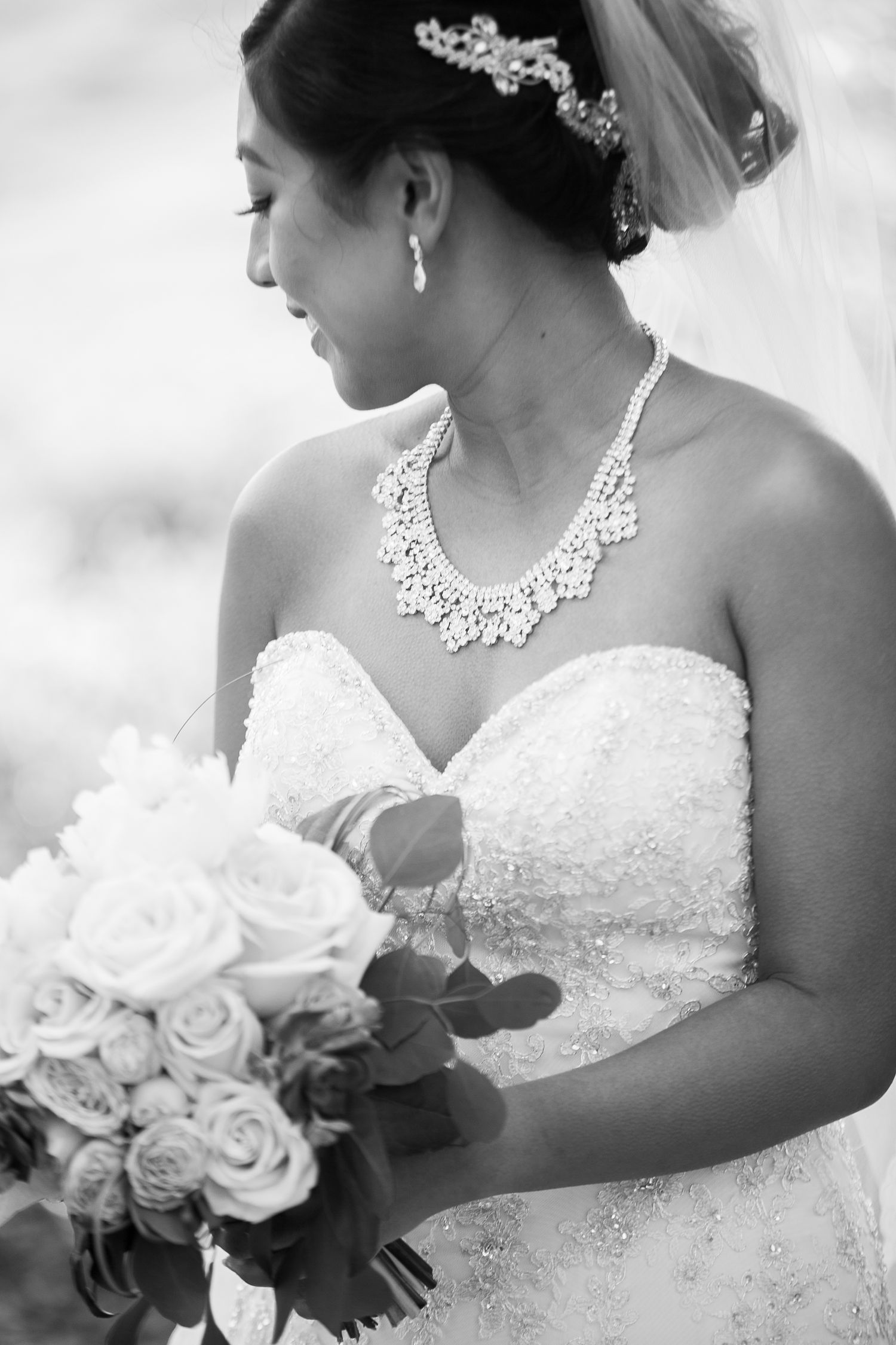 Classic black and white bridal portrait showcasing elegant jewelry and lace dress.