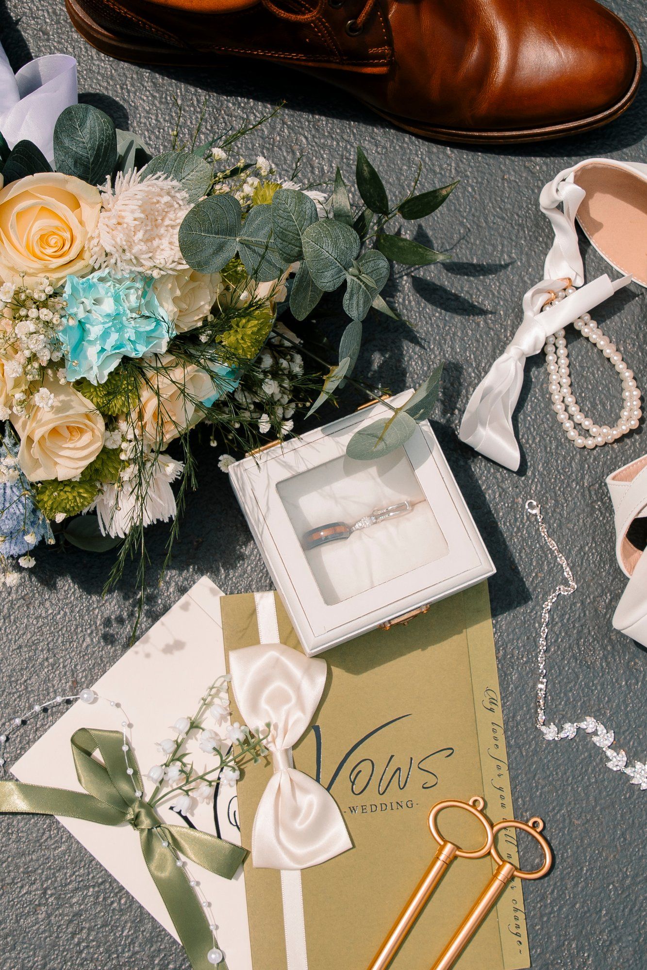 Wedding vows display with floral arrangements, ribbons, and pearls creating an elegant setup against a textured background.