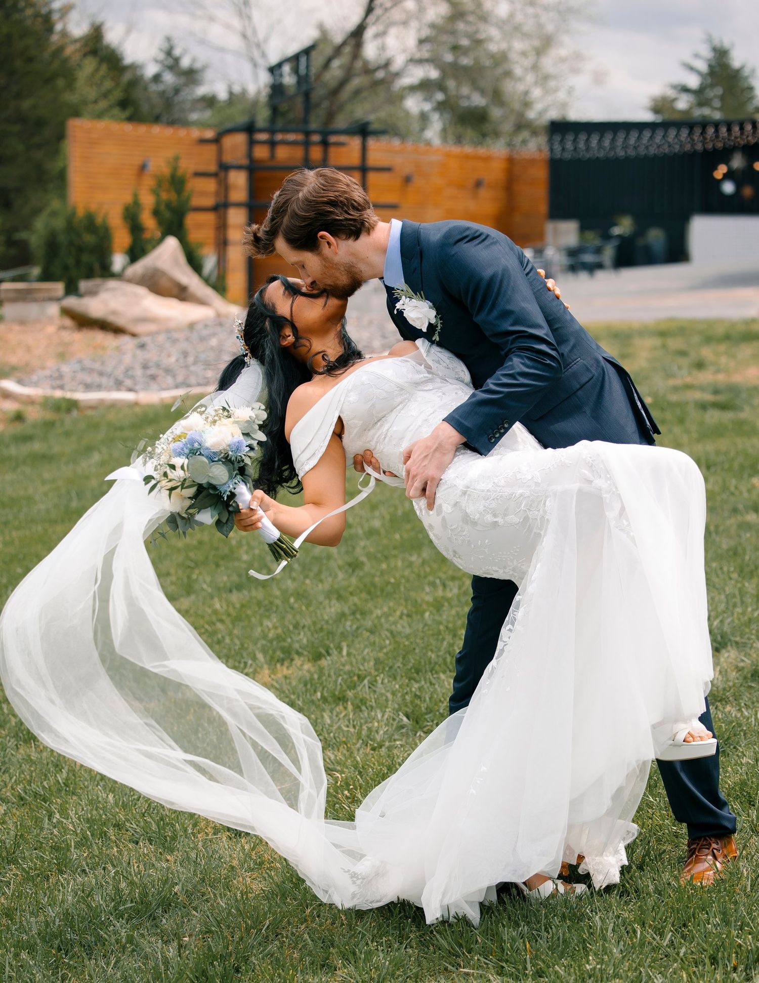 A series of romantic dip poses on a lawn showing a flowing white wedding dress gracefully trailing in the sunlight.