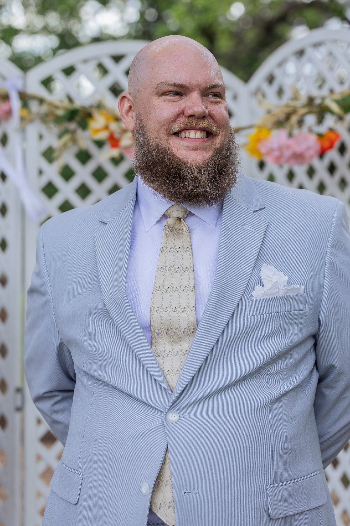 Three sequential photos showing someone wearing a light gray seersucker suit with cream tie against a white lattice backdrop.
