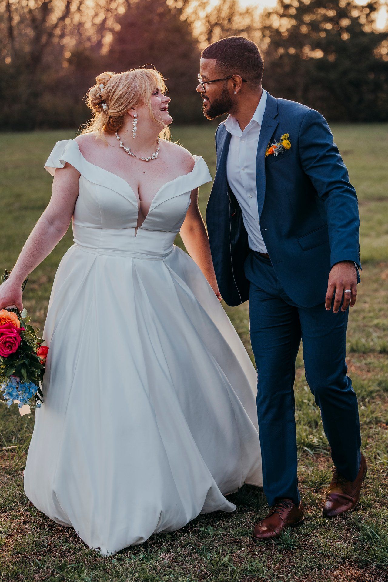 Joyful newlyweds sharing candid moment in outdoor wedding setting.