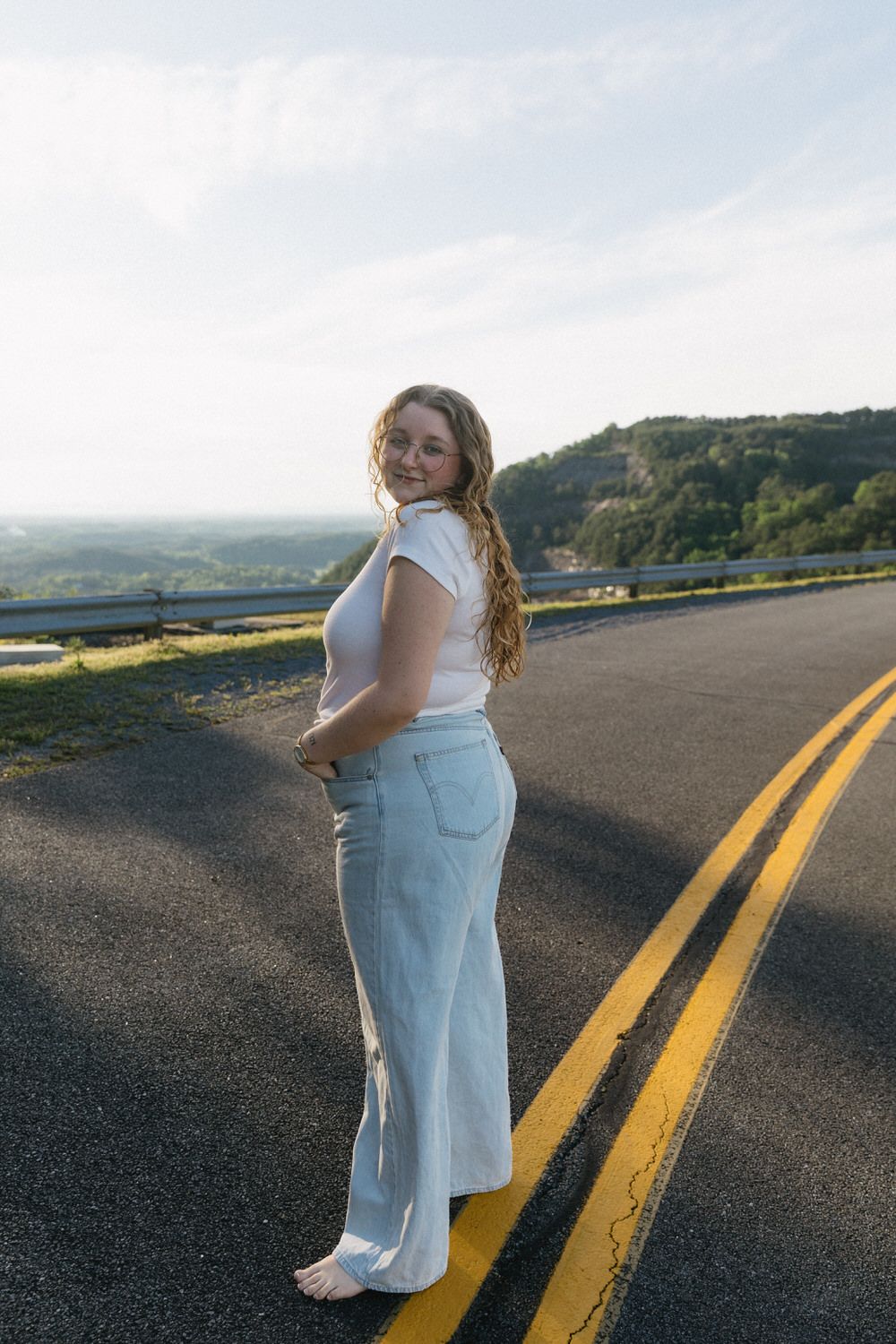 Photographer, Sydney, smiles over her shoulder at the beautiful Carter's lake dam.