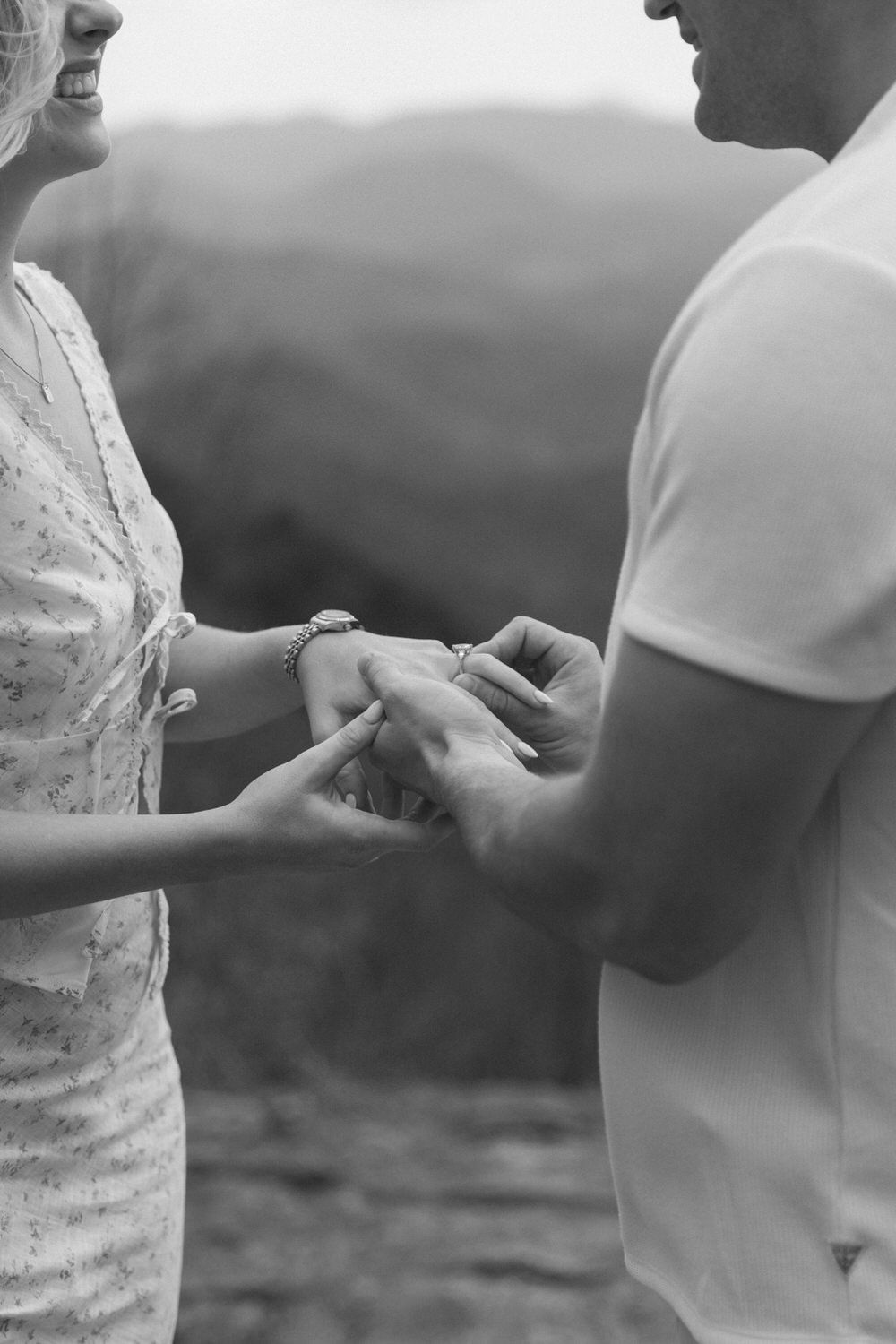 A close-up black and white shot of hands exchanging rings during an intimate outdoor elopement moment at preachers rock.