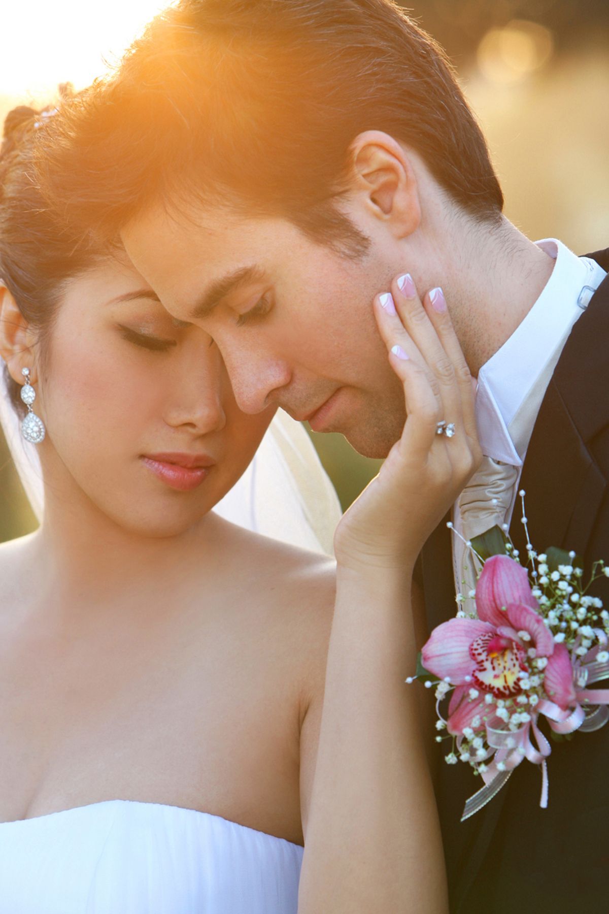 Soft-focus sunset wedding portraits with delicate floral bouquet details.
