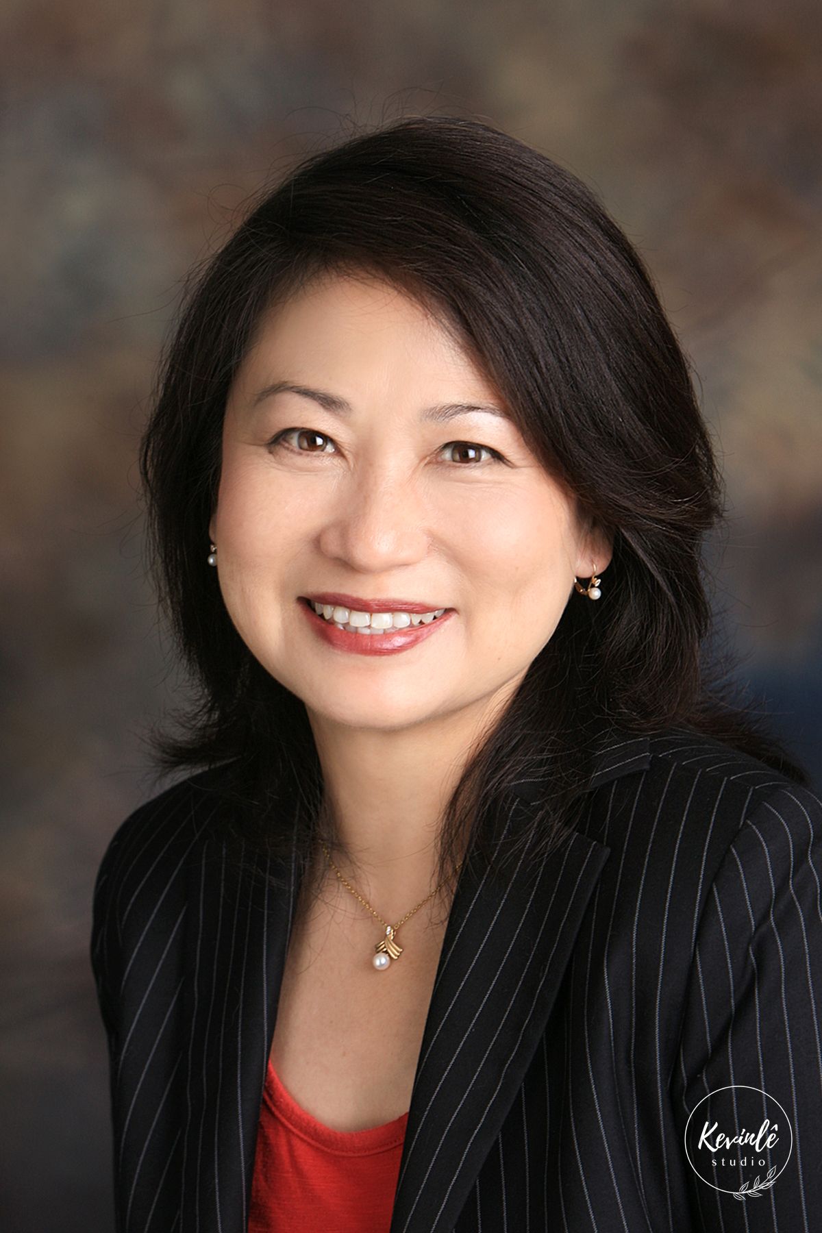 Professional business headshots showing someone in black blazer and red top against dark background.