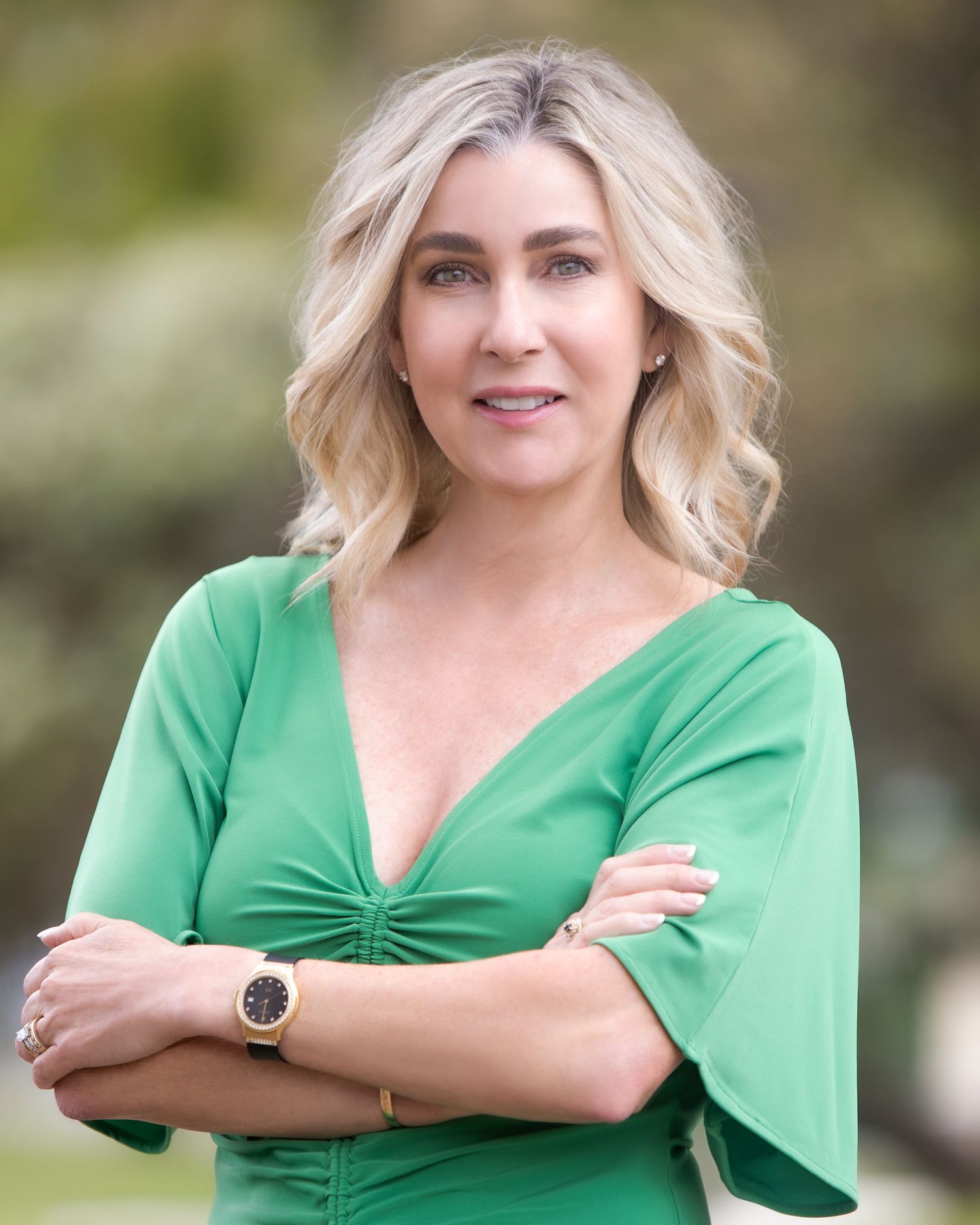 Professional headshots of someone wearing a green blouse against a blurred outdoor backdrop.