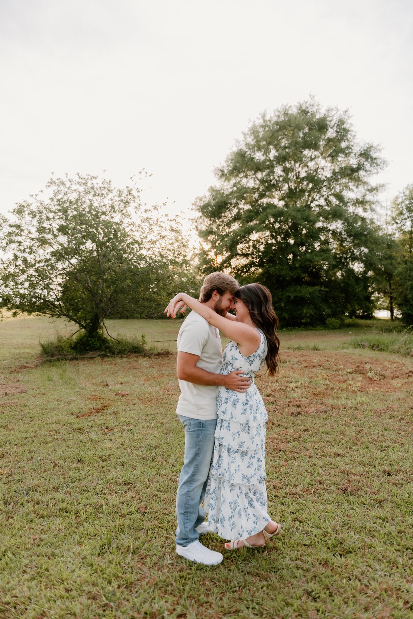 A couple in an open field during sunset share a tender moment together in a sequence of romantic photographs.