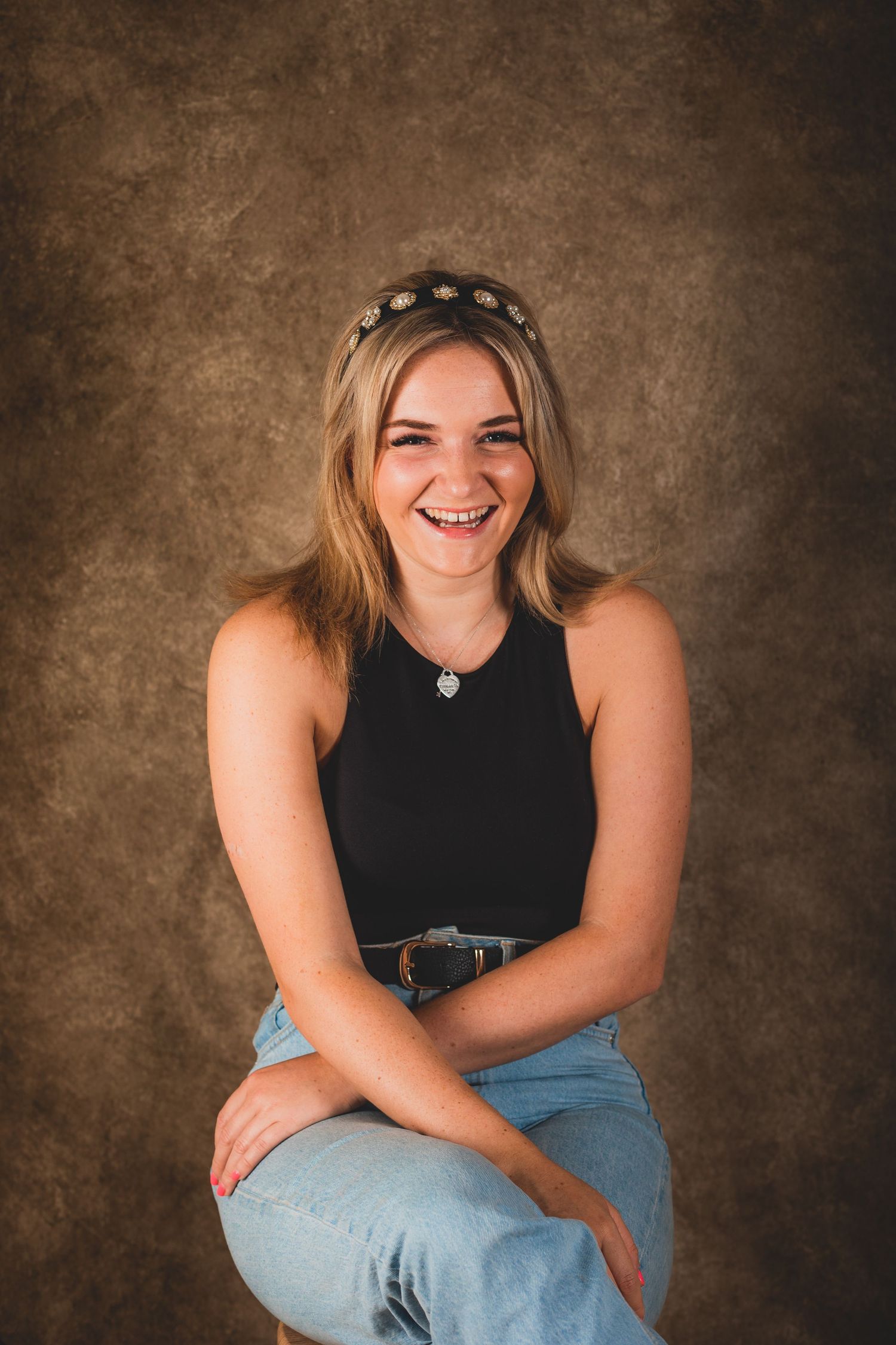 Natural studio portrait sequence showing joyful expressions and casual poses against textured brown backdrop.