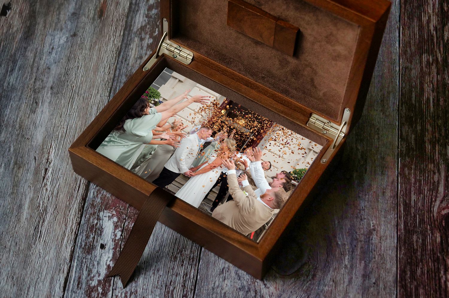 A vintage wooden box filled with old photographs and nostalgic memories sits on weathered wooden planks.