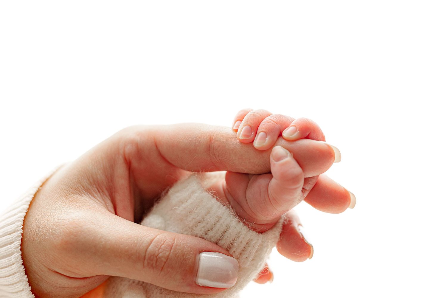 A baby's hand gently grasps an adult's finger against a white background. The image conveys warmth, tenderness, and a sense of protection.