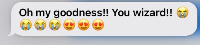 Text message with happy emojis calling someone a wizard.