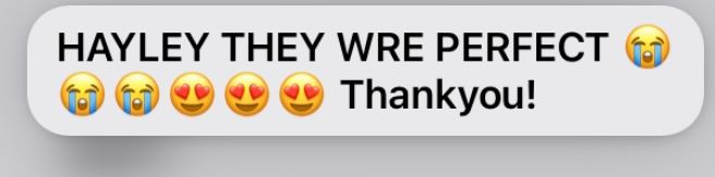 A social media comment displaying positive feedback with heart and smiling emoji icons.