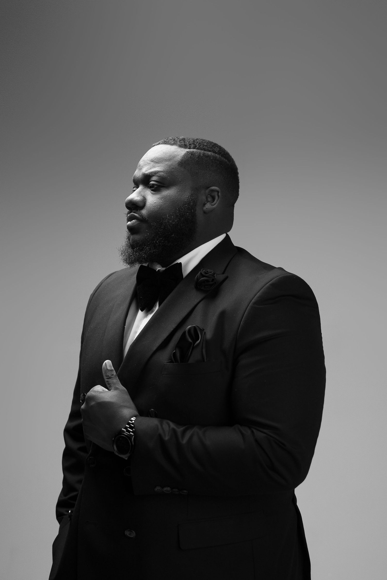 Black and white portrait series of a person in a formal suit against a studio backdrop.