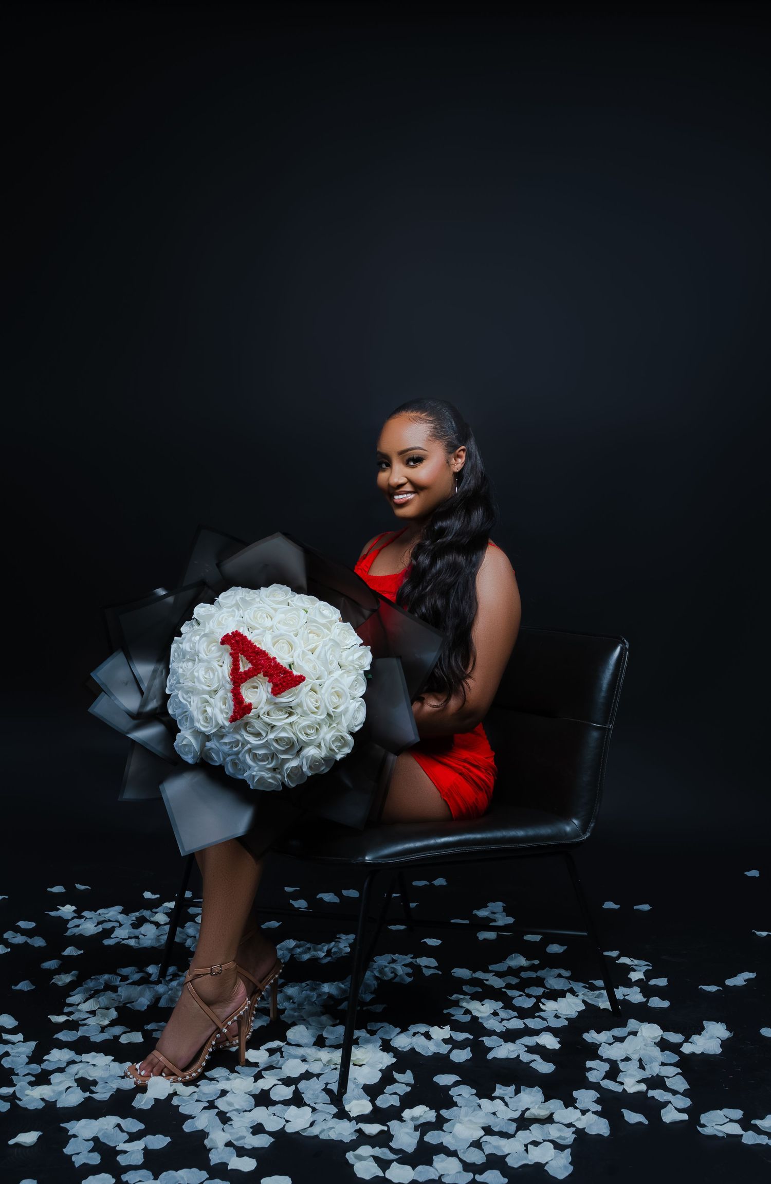 Artistic portrait with white roses and scattered petals against dark background.