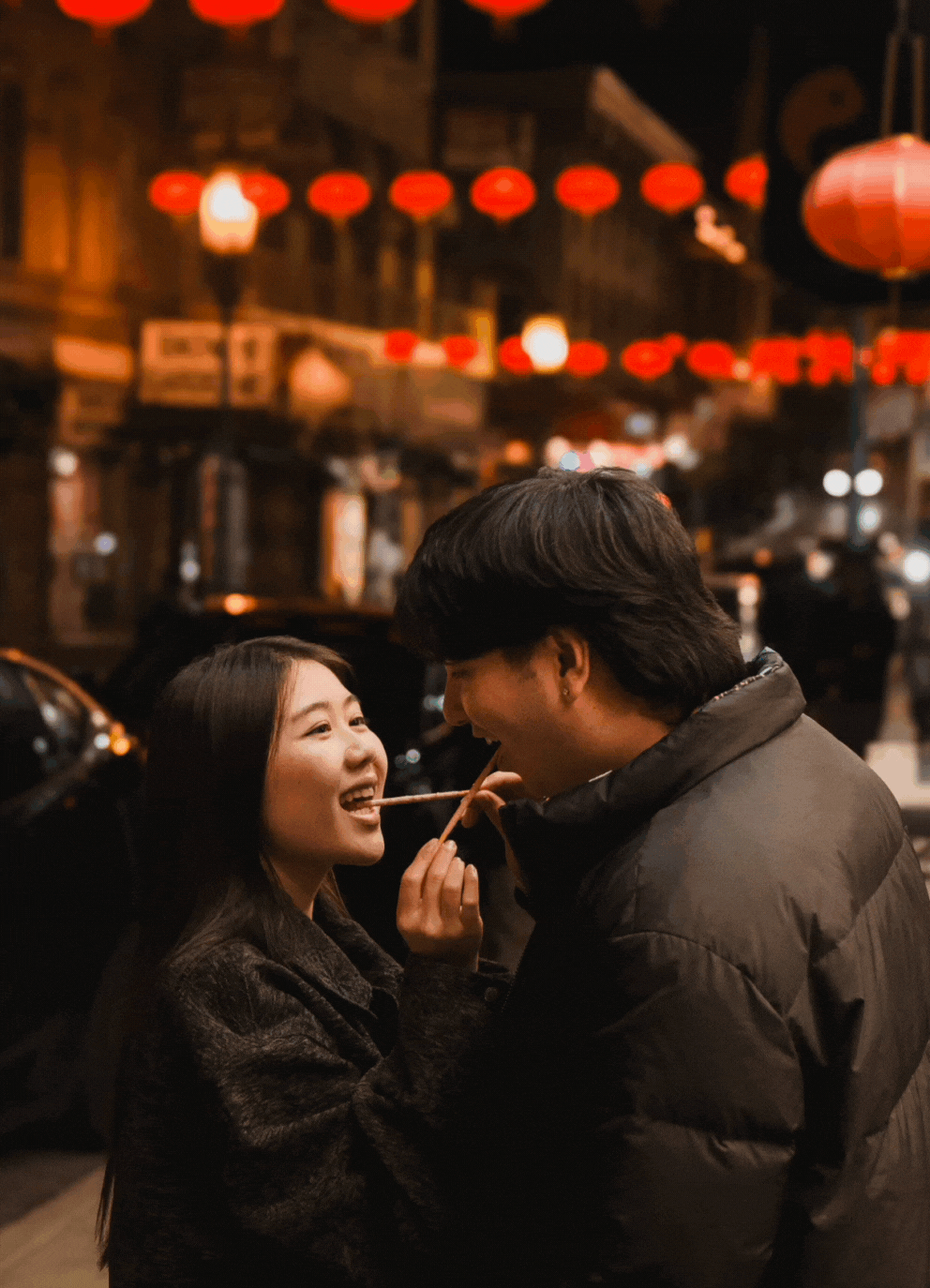 A GIF of a couple feeding each other candy in an adorable way in Chinatown, San Francisco.