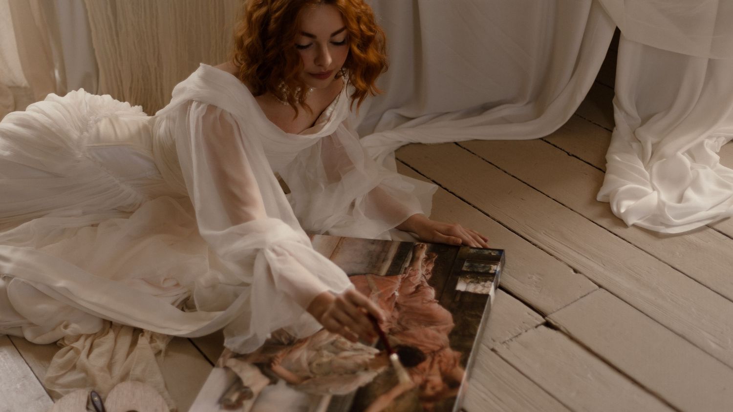 Couple holding hands and dancing together on a rustic wooden floor in romantic candlelight.