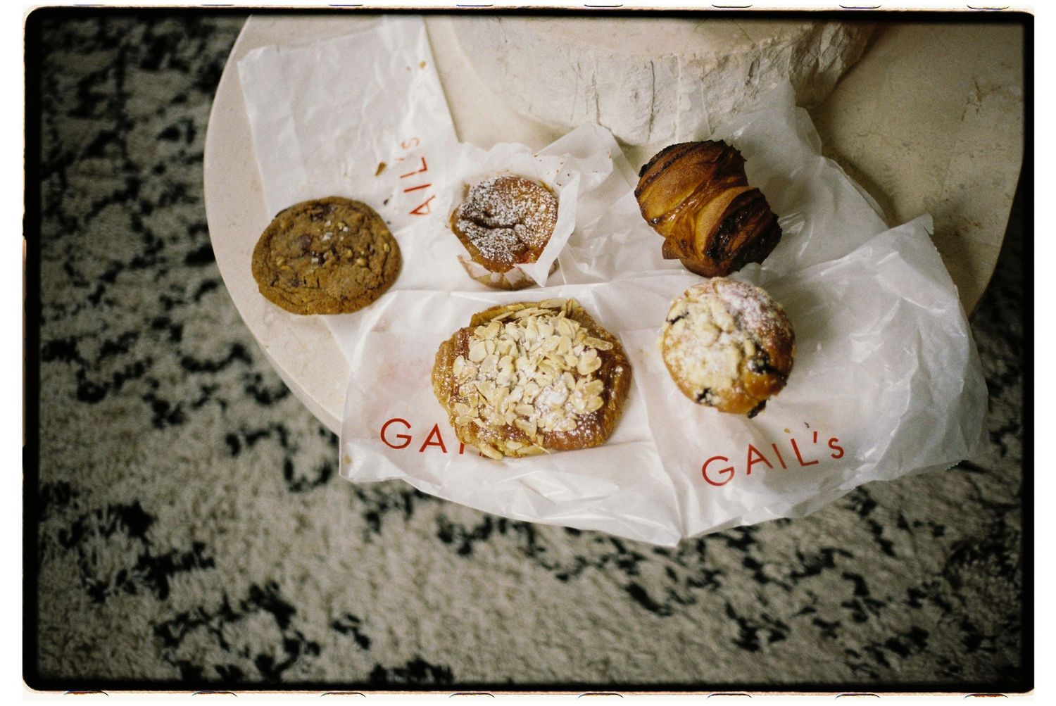 Various pastries and baked goods displayed on white paper with 'CALL' text visible in vintage film photography style.