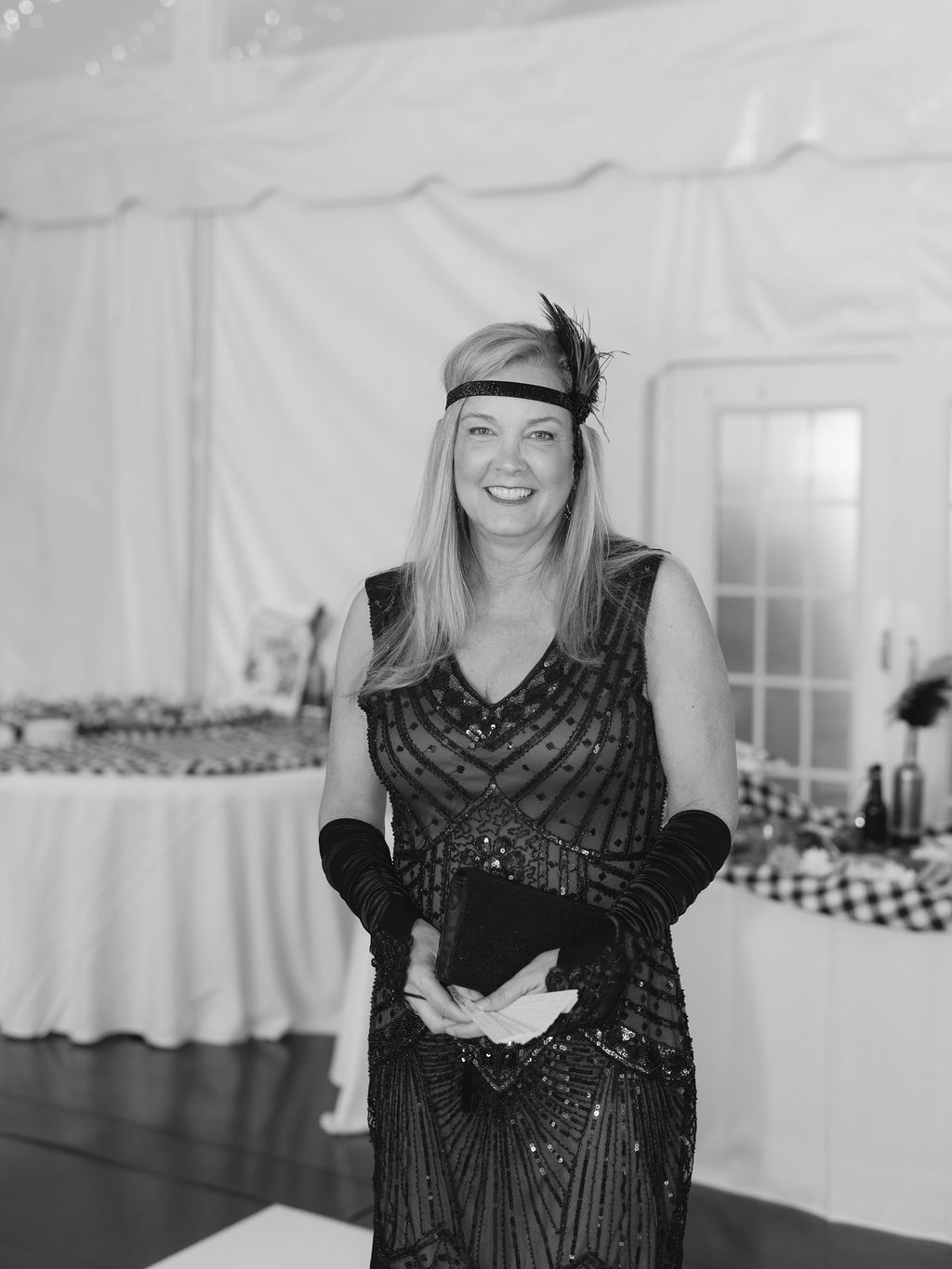 A collection of black and white photos showing someone in a vintage-style black dress at a formal indoor event.