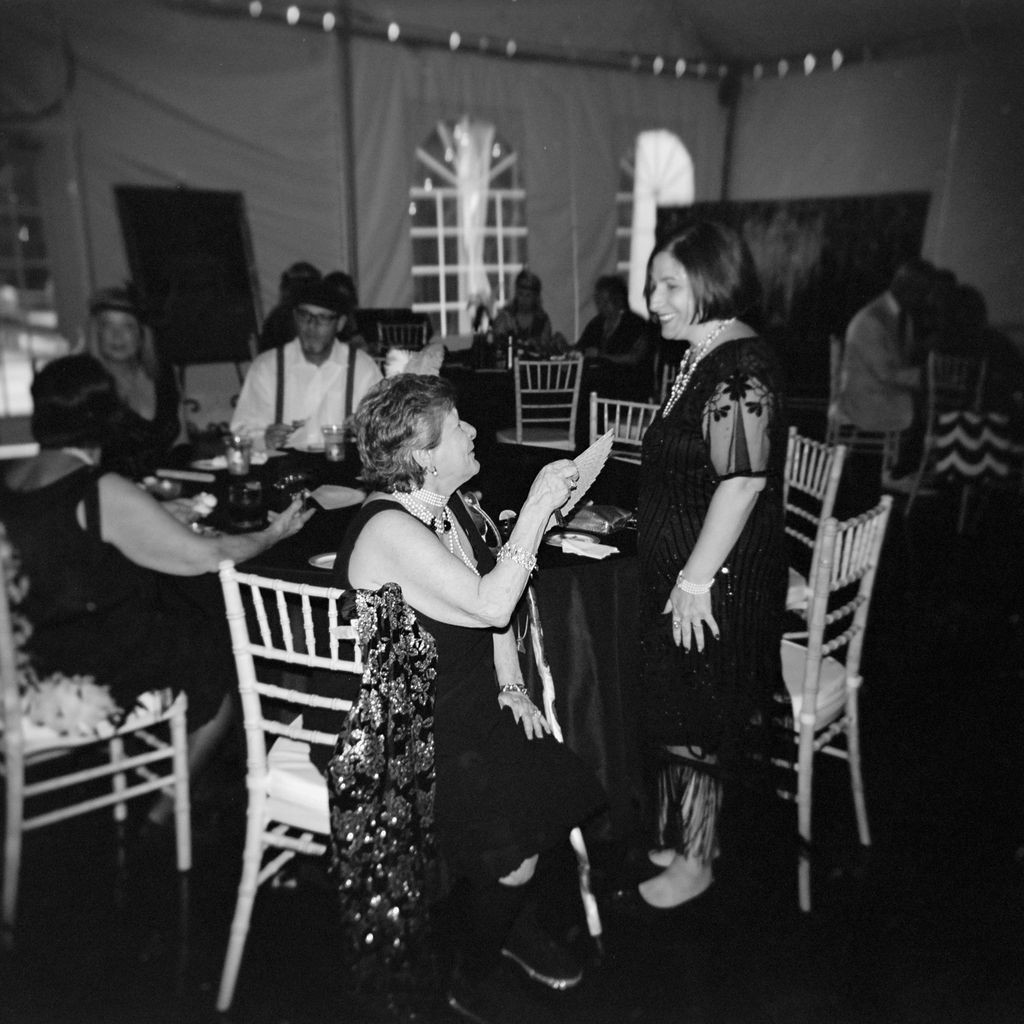 Black and white photographs of guests dancing and socializing during a celebratory event on a dance floor.