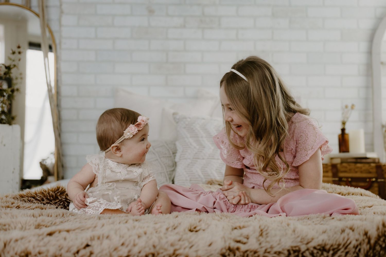 A tender moment between mother and baby on a plush bed with neutral decor.