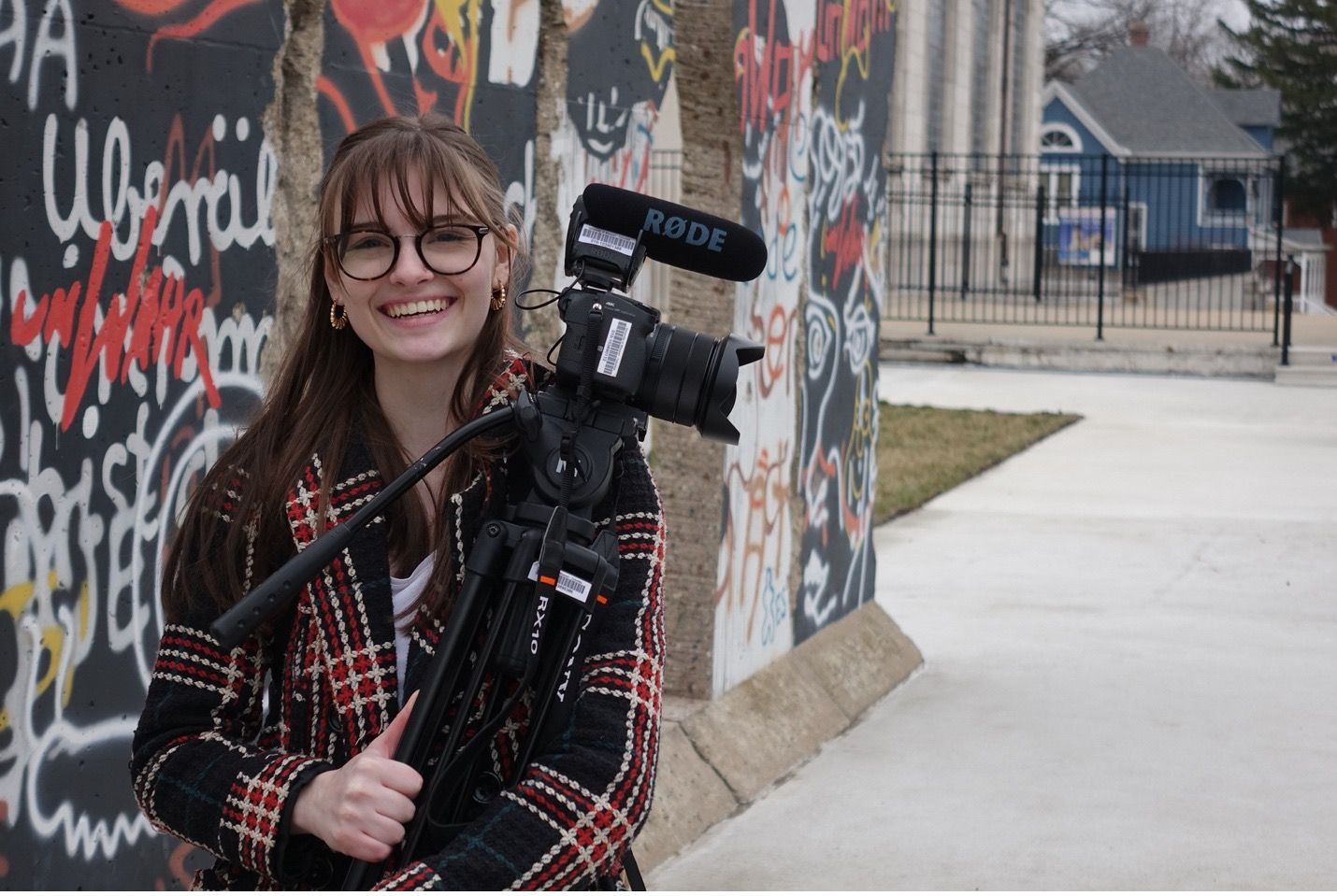 Emma Rae Gerwen stands next to a section of the Berlin Wall located in Missouri.