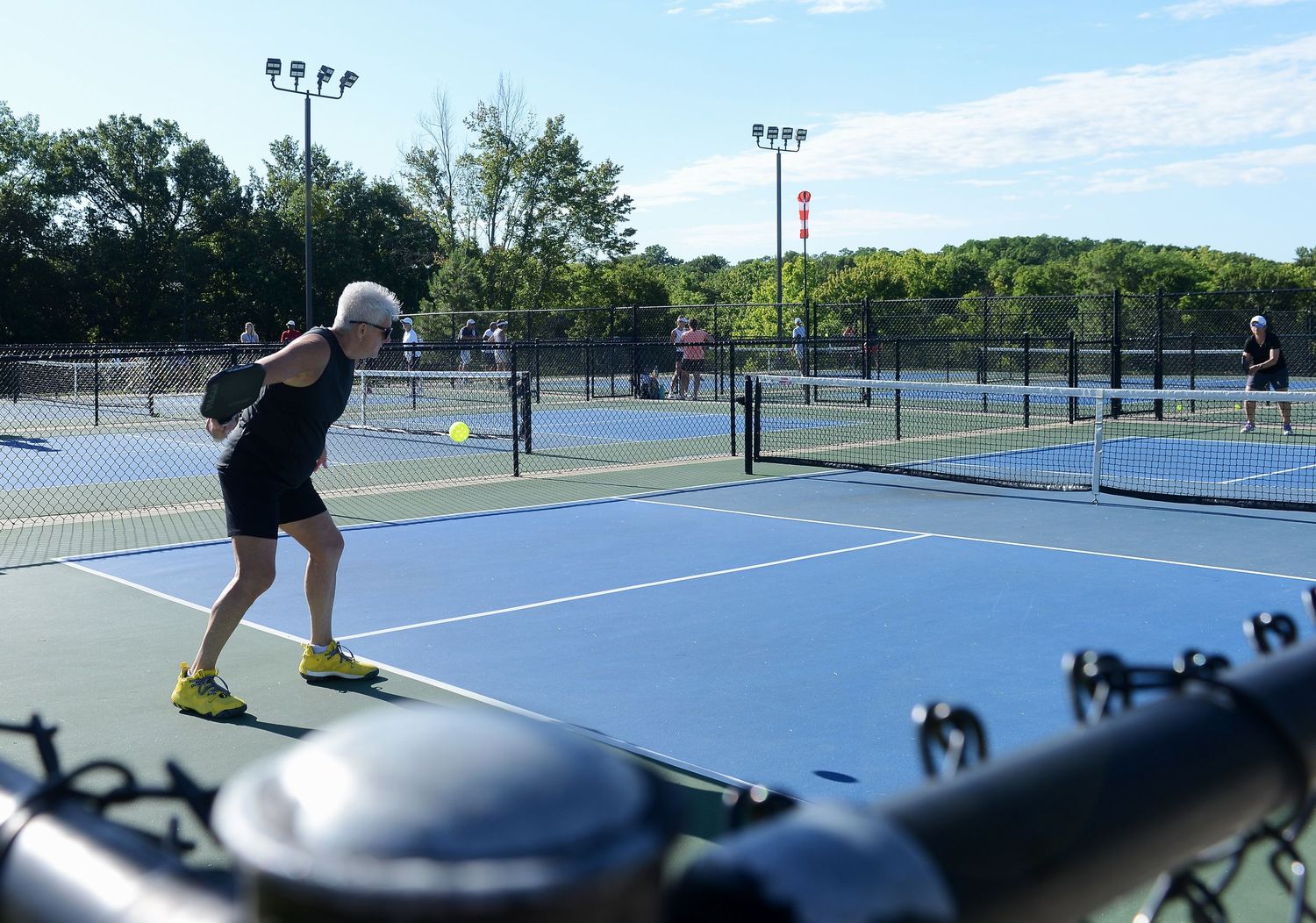 A woman hits a ball to return a serve on a pickleball court in Columbia, Missouri.