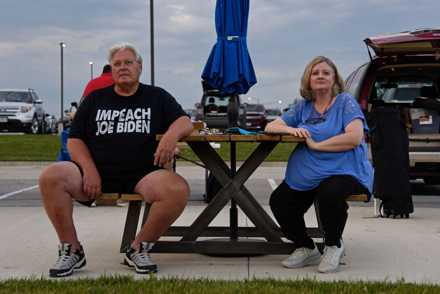 Ed Corcoran, left, and Christy Pinnell observe the debate from a picnic table seated near the back of the lawn Thursday in Ashland.