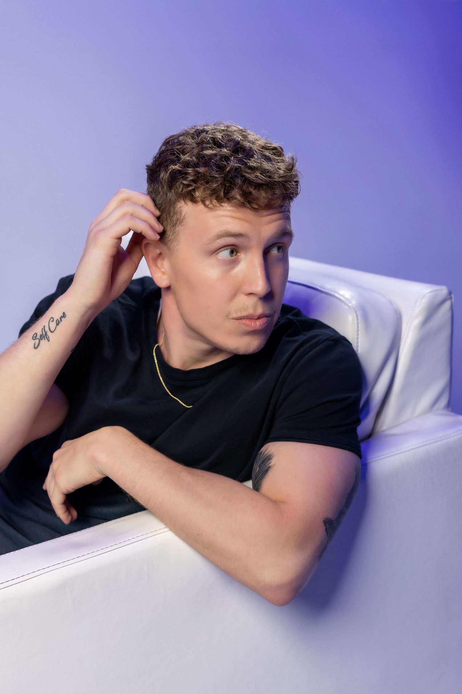 A series of casual poses against a white background with purple lighting depicts someone wearing a black t-shirt.