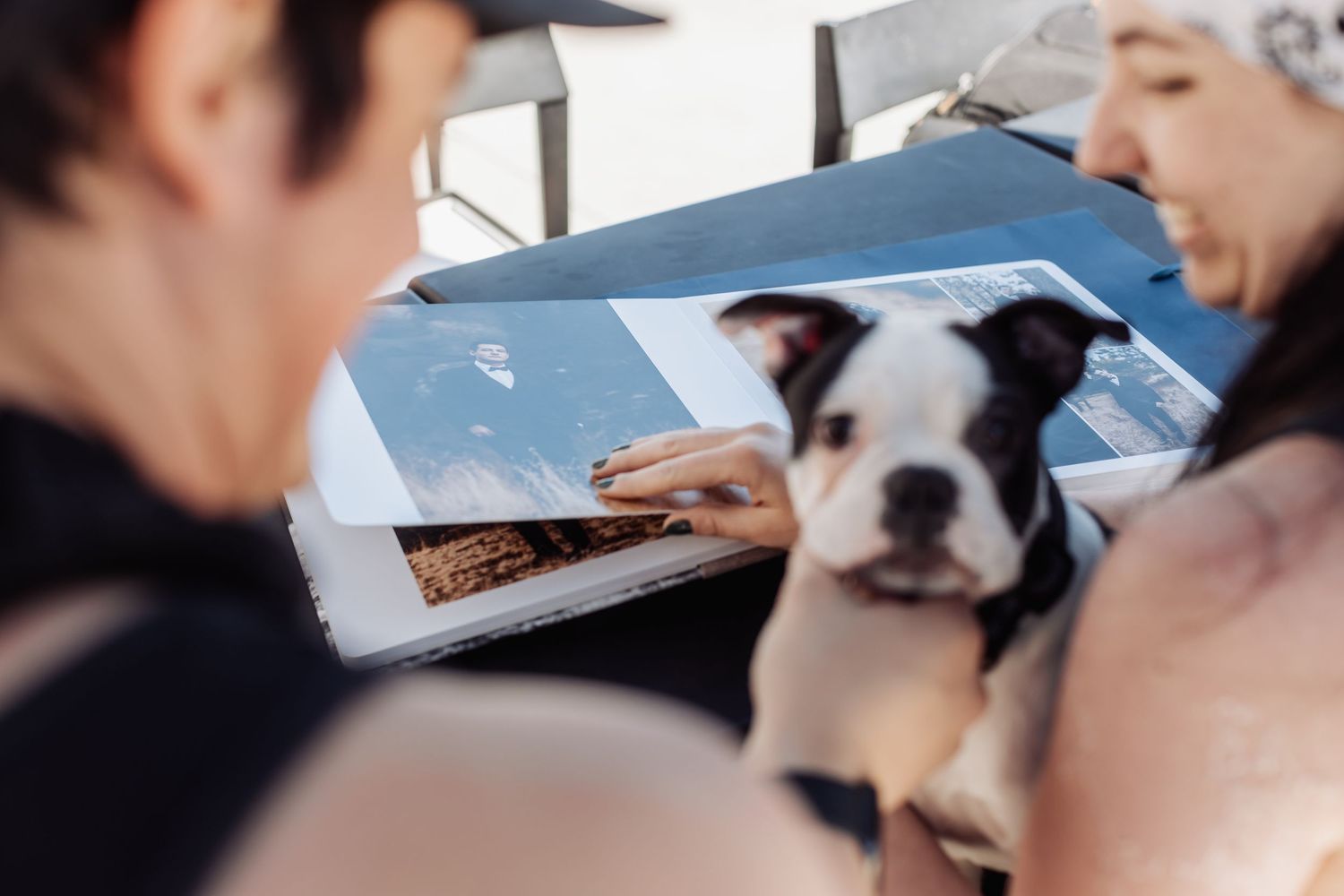 A black and white dog looks on as two people review documents at a table together.