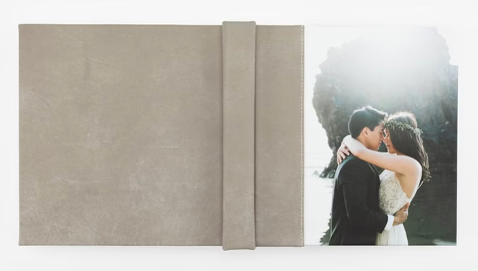 A romantic modern wedding couple embraces in an elegant architectural setting bathed in soft natural light.