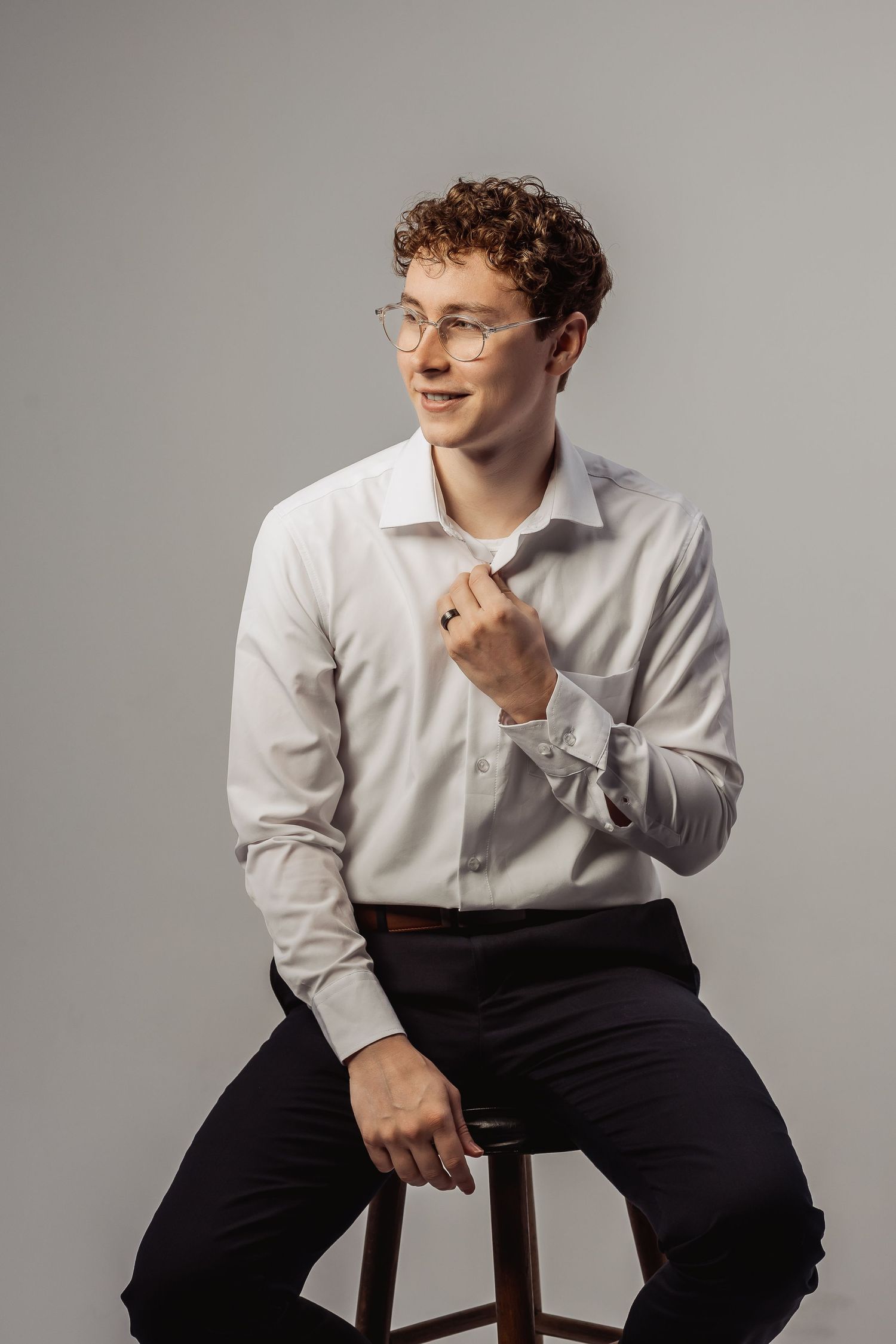 Portrait series featuring relaxed poses on a wooden chair in professional attire.