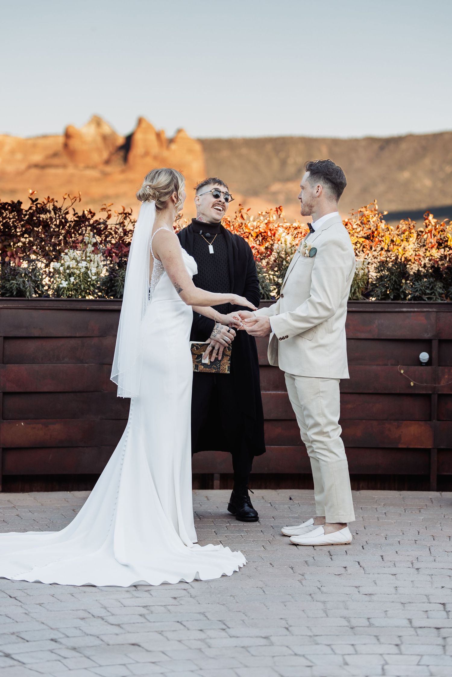 A wedding ceremony takes place at sunset with scenic mountain views in the background.