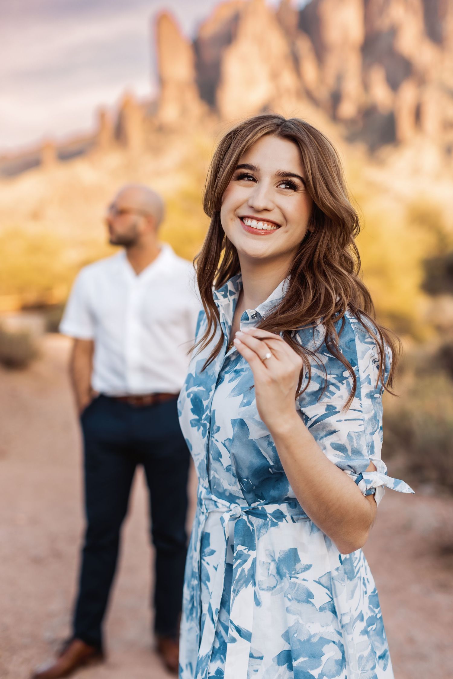 Beautiful desert engagement photo with stunning mountain backdrop and natural lighting.
