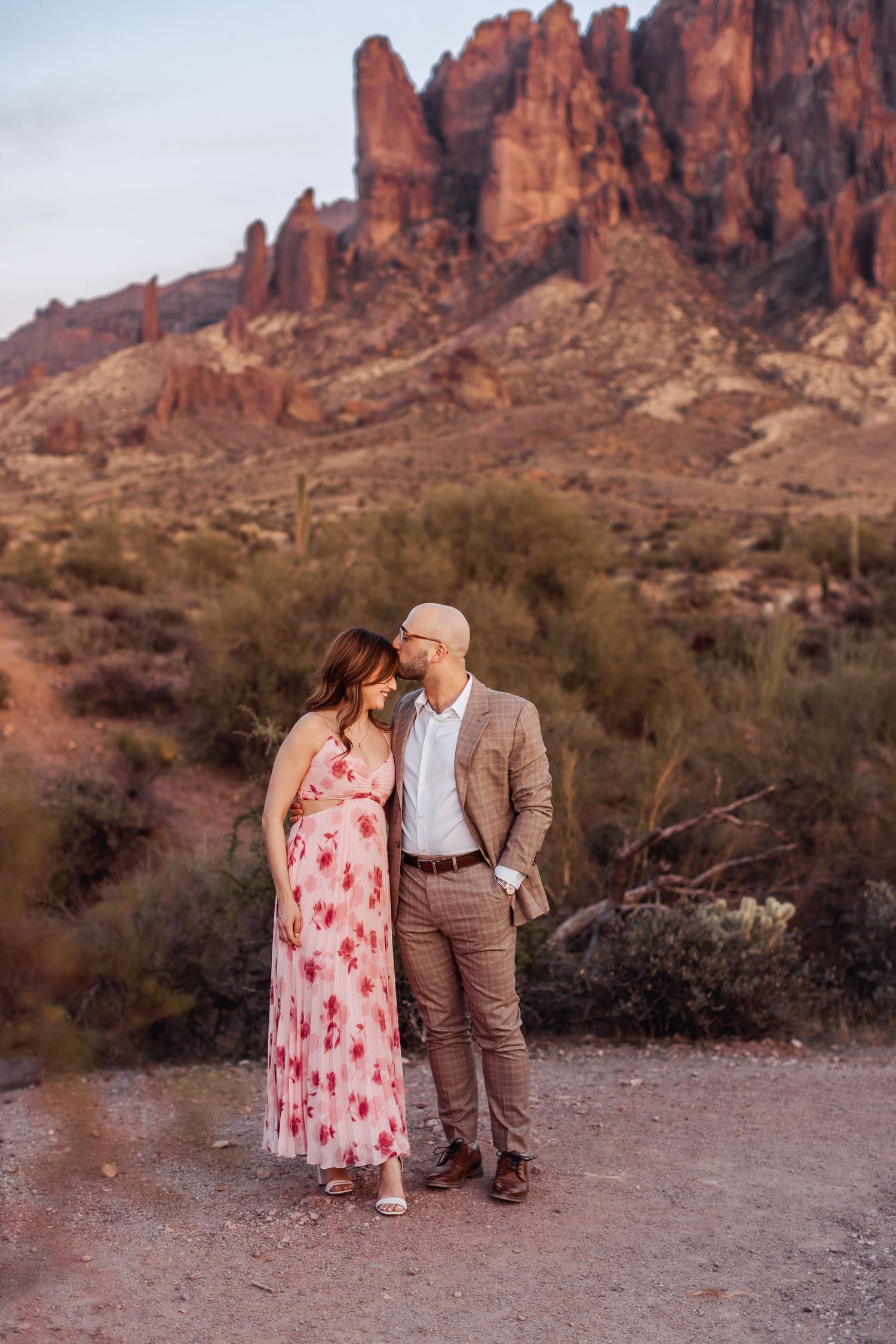 Romantic sunset portrait against majestic desert mountain landscape.