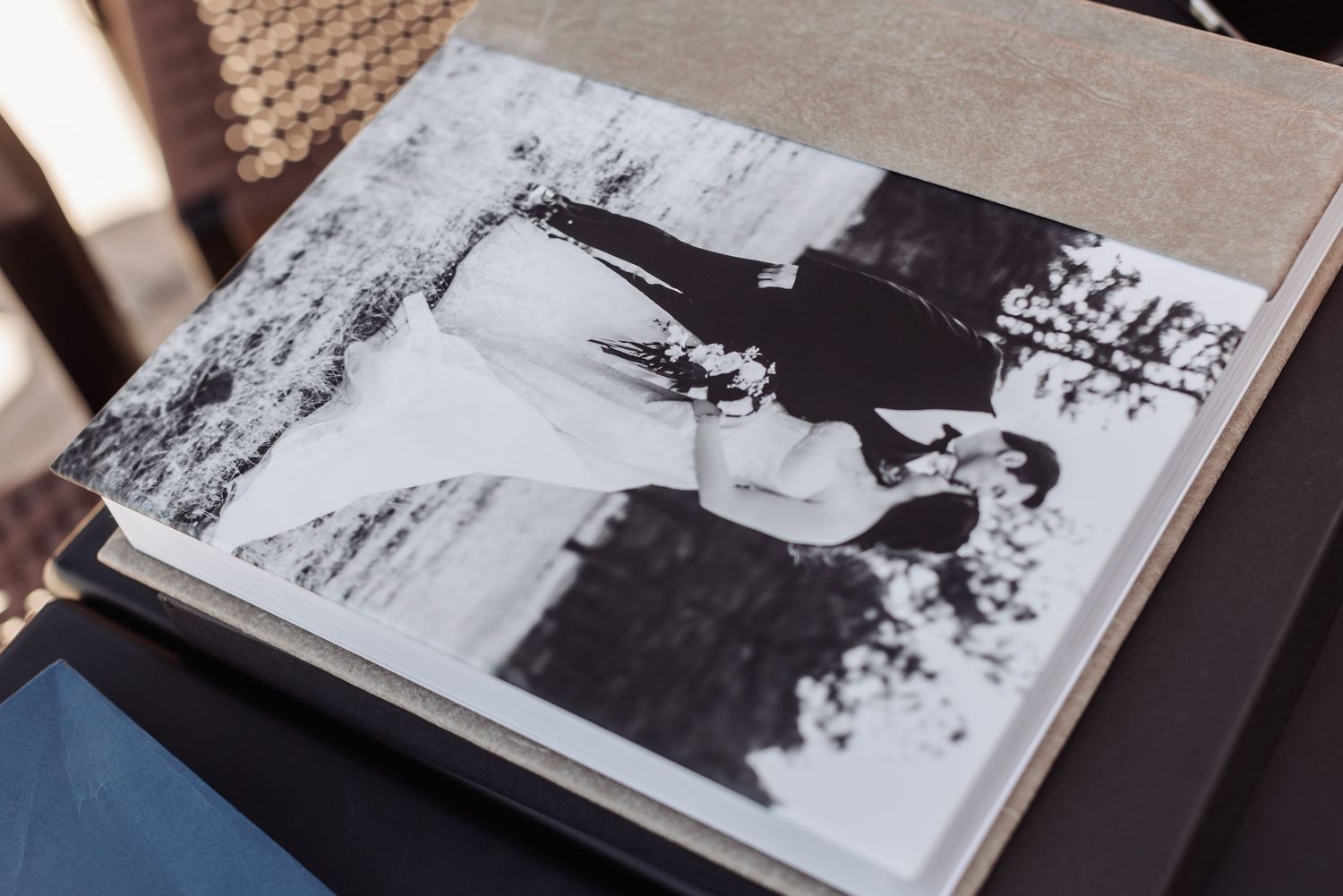 A black and white vintage photograph displayed in a photo album shows a couple walking together outdoors.