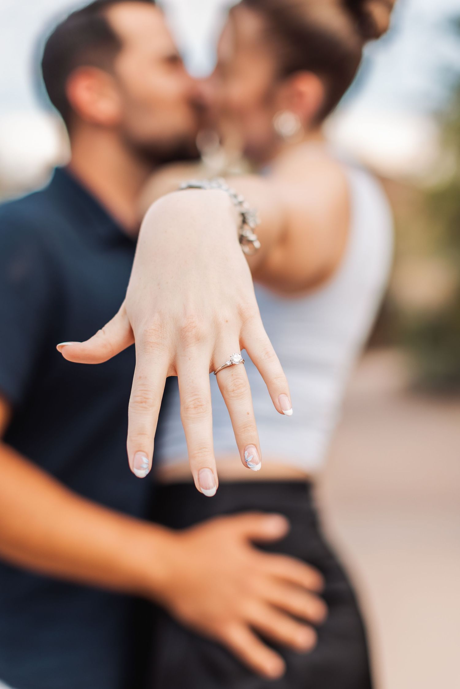 A close-up sequence showing a person's hand displaying an engagement ring from multiple angles.