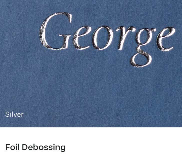 Close-up of elegantly designed typography showing 'George' text with silver foil debossing effect on blue background.