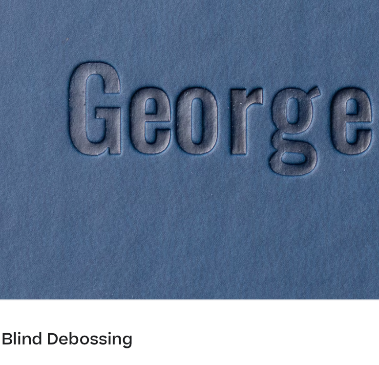 The word 'George' embossed with blind debossing technique on blue textured paper creating a raised letterform effect.